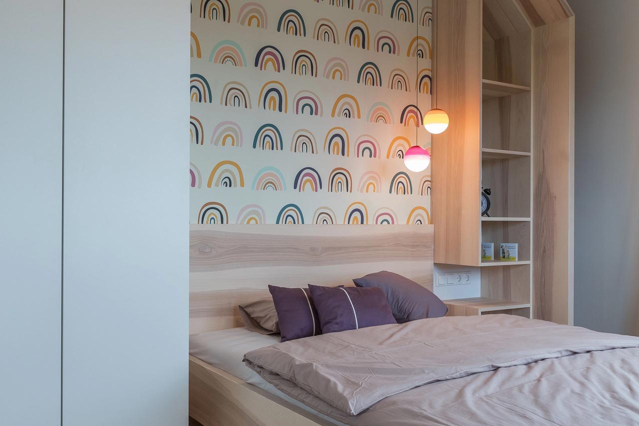 Kinderzimmer mit Hausbett und bunter Regenbogen-Tapete