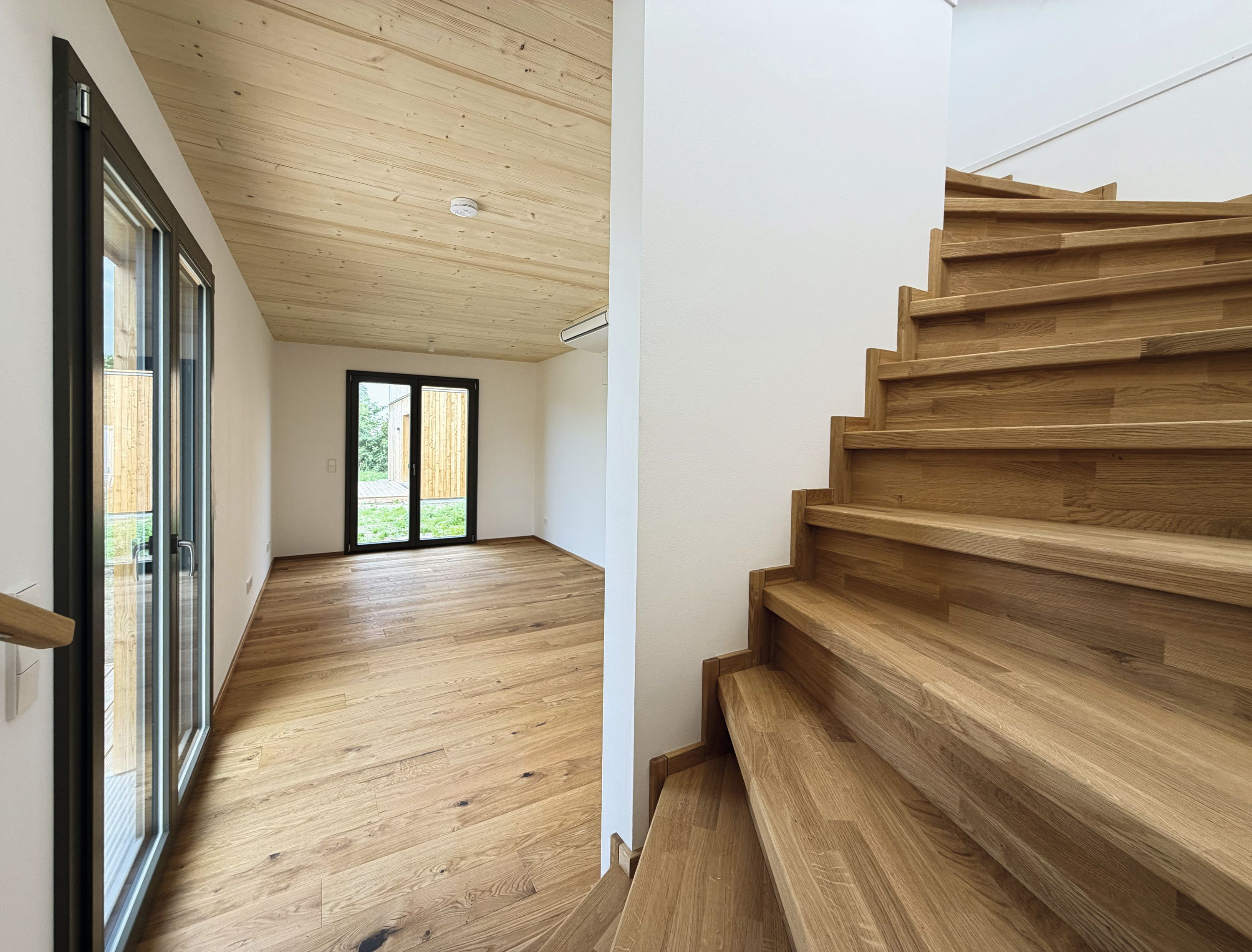 Gewendelte Eichentreppe und Flur mit Blick in den Garten