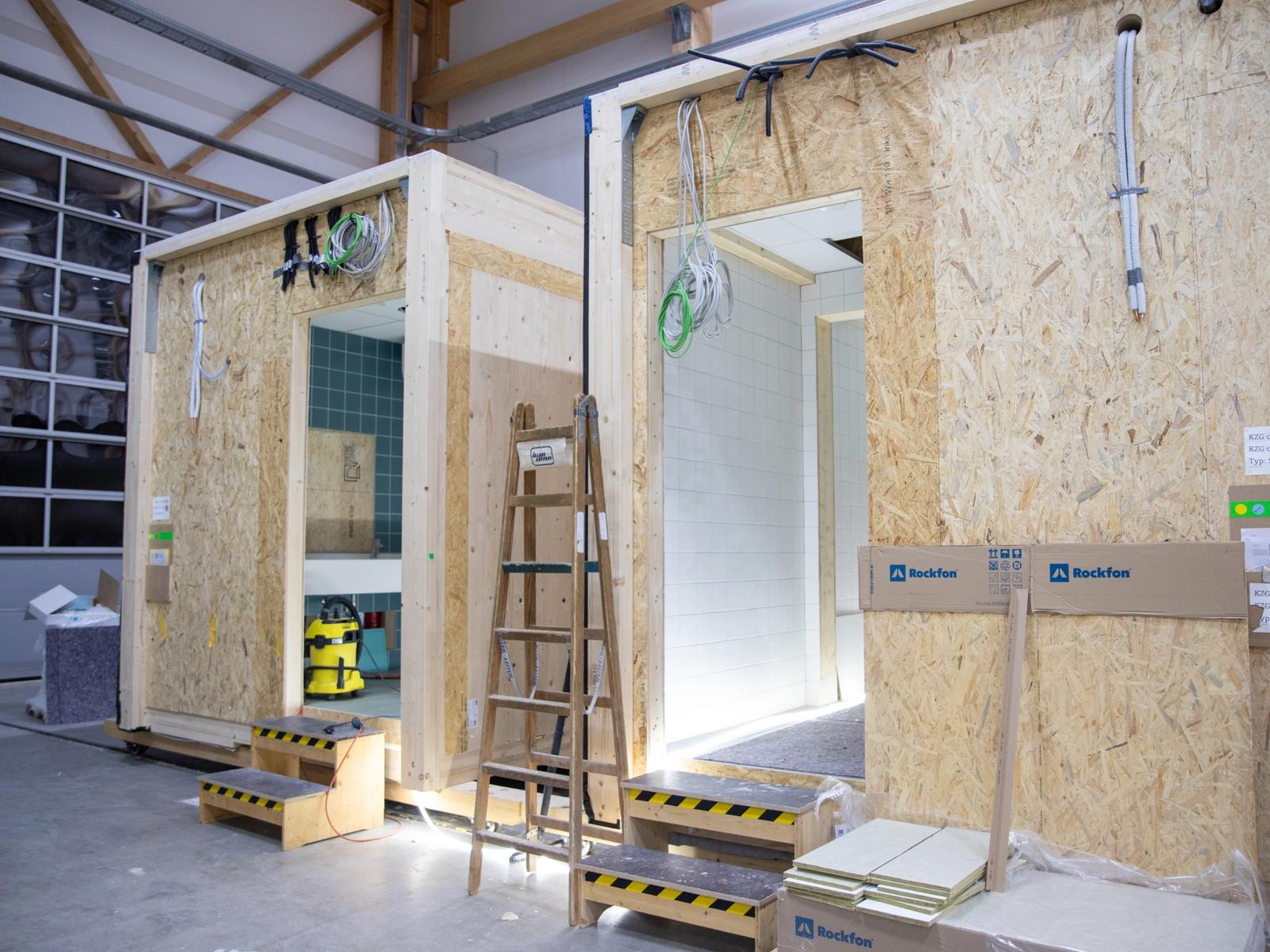 Sanitärmodule mit Stehleiter und Materiallager in der Produktionshalle der Zimmerei Stark