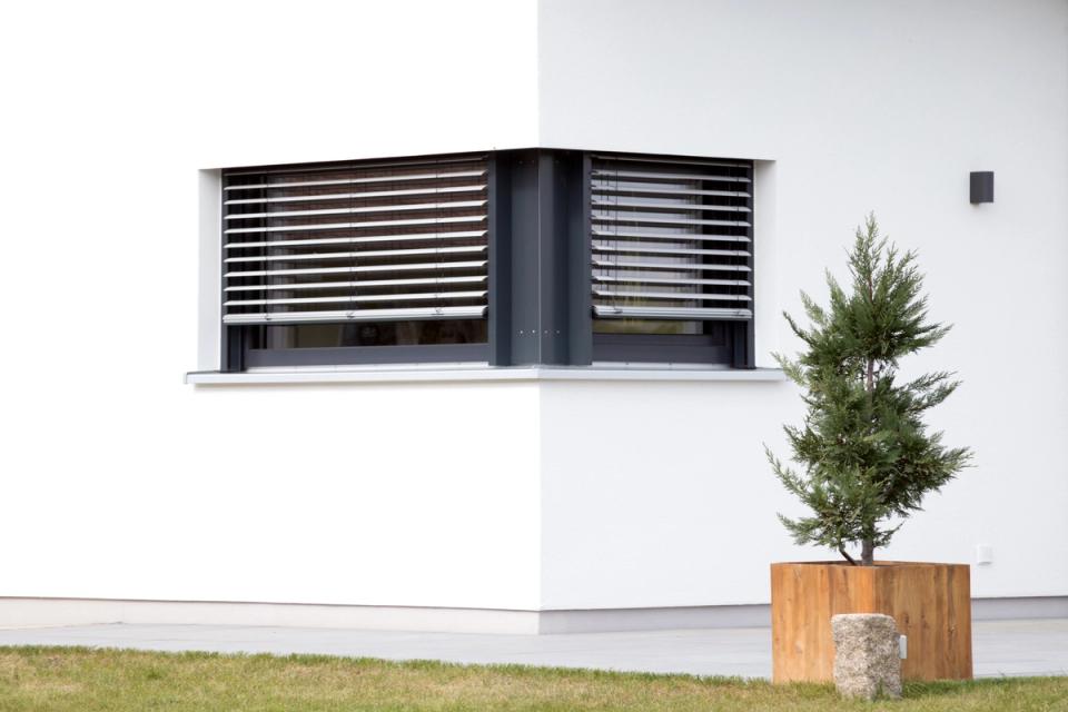 Eckfenster mit Raffstore-Beschattung an weißer Fassade