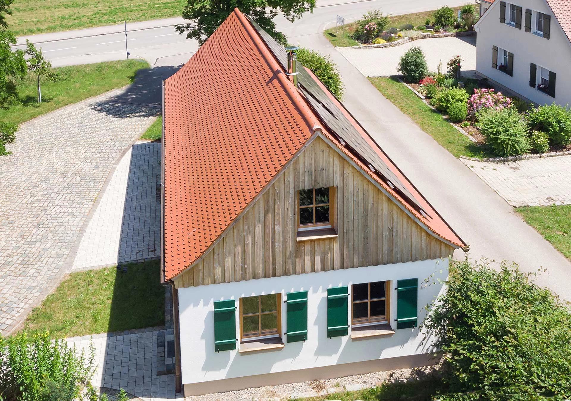 Brennerei — Außenansicht Holzhaus mit grünen Läden, Luftbild