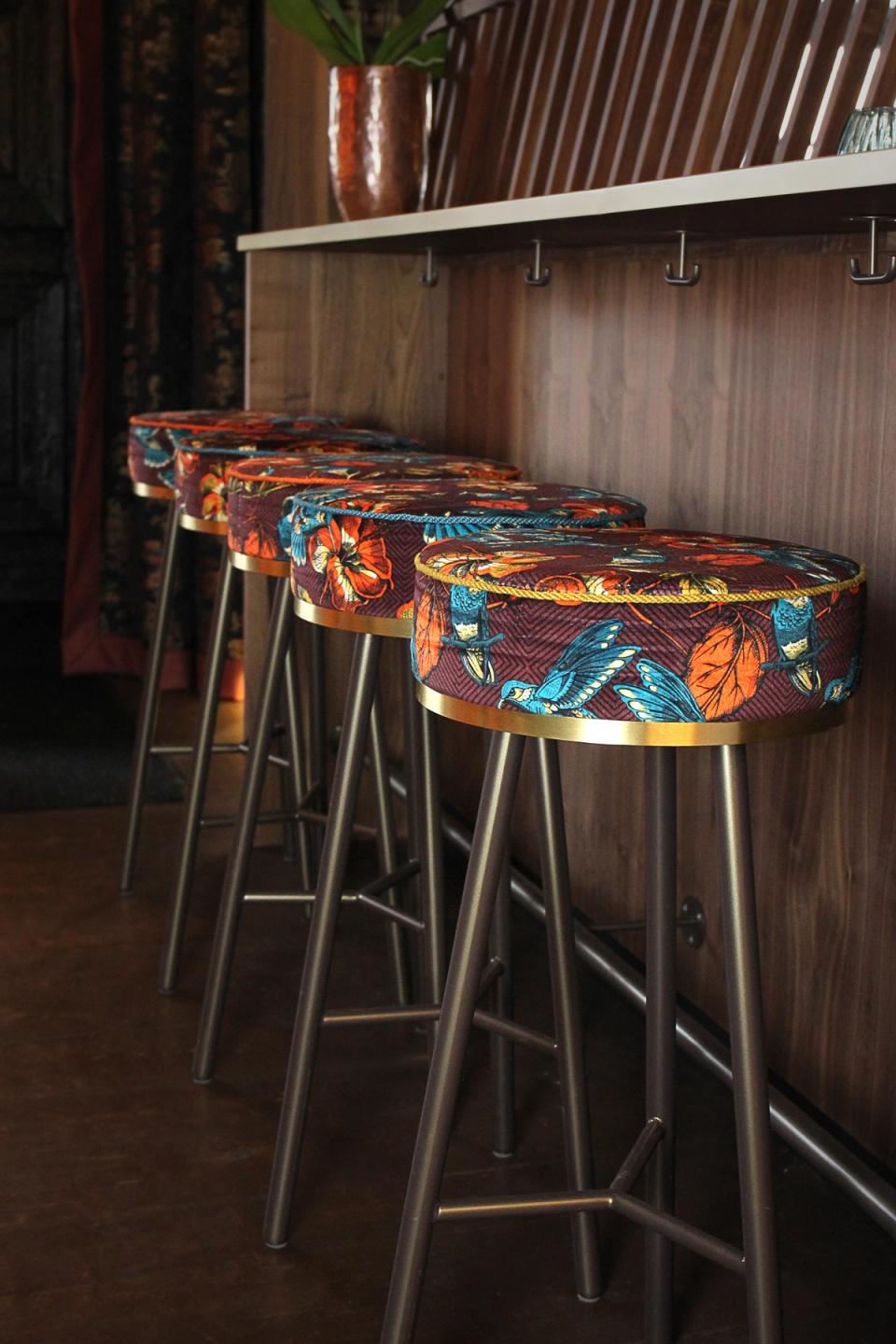 Restaurant München — asiatisches Restaurant mit bunten Barhockern, Holzvertäfelung, stilvolles Interieur