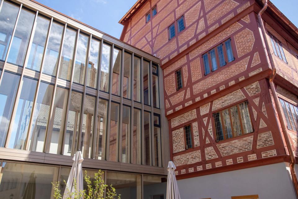 Glasanbau mit Holzsprossen neben restauriertem Fachwerkgiebel