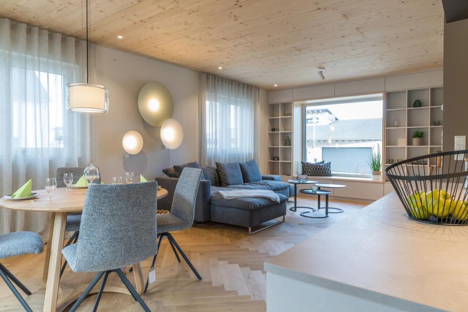 Wohnzimmer mit blauem Sofa, runden Wandleuchten und Fenstersitzbank