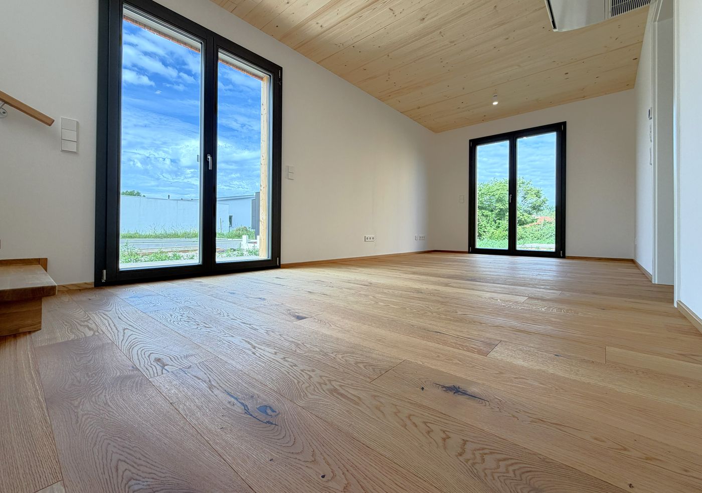 Der Wohnbereich mit seinen großen Fensterflächen verbindet Innenraum und Terrasse.