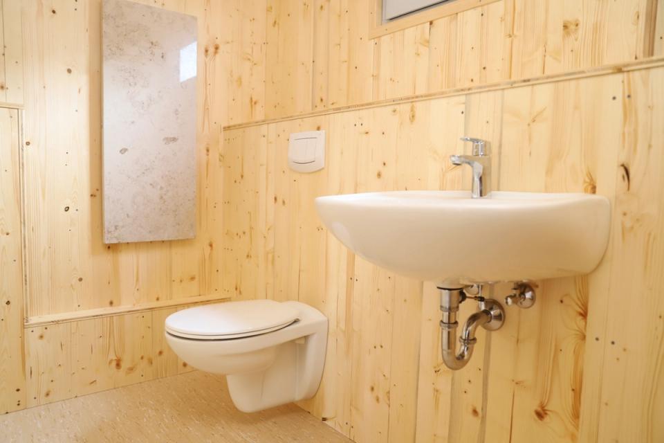 Waschraum im Waldkindergartenwagen mit Toilette und Waschbecken an der Holzwand