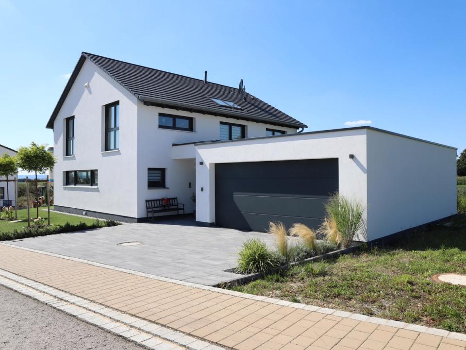 Straßenansicht weiße Villa mit Doppelgarage und Satteldach