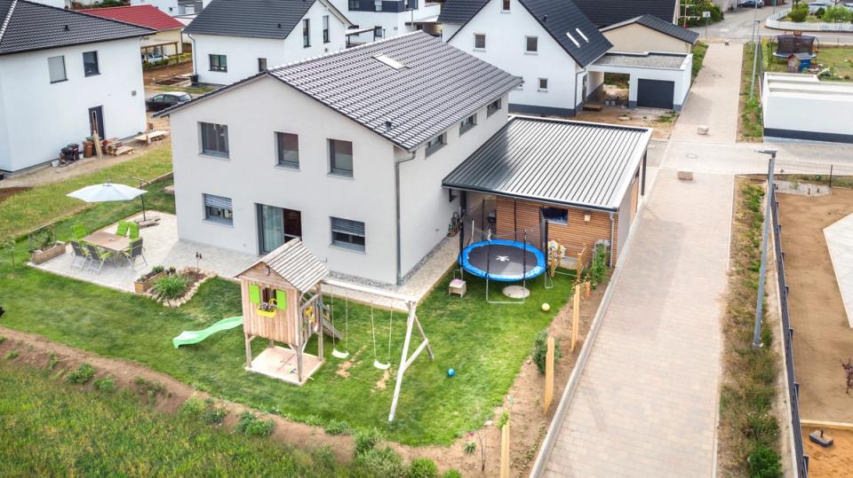 Luftaufnahme von Haus mit Garten, Spielhaus, Trampolin und Terrasse