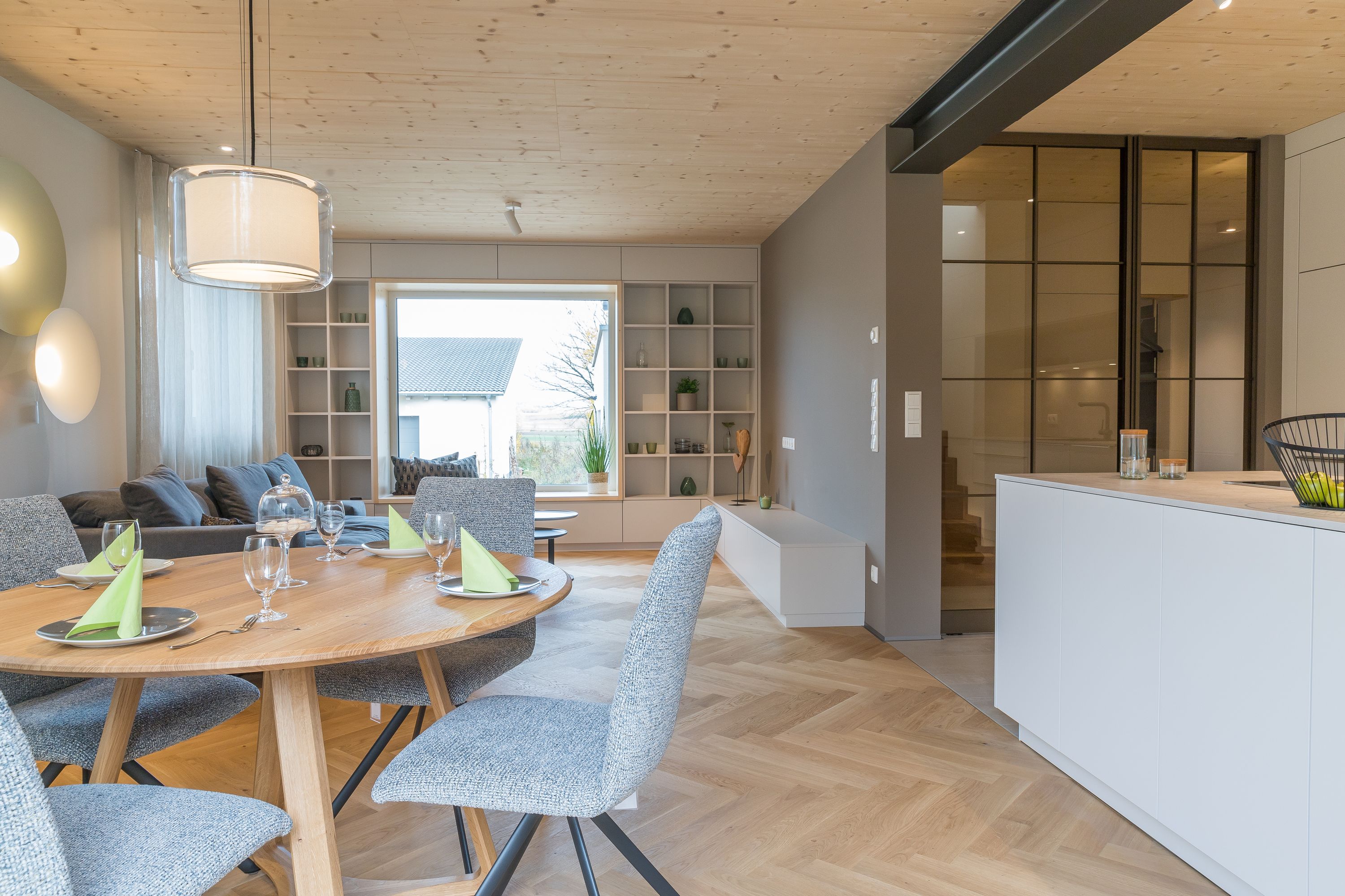 Offener Wohn- und Essbereich mit Blick auf Küche und Holztreppe