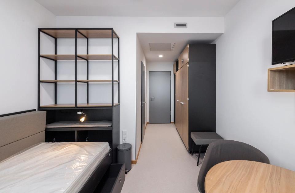 Zimmer mit Einbauschrank, offenem Regal und Schreibtisch