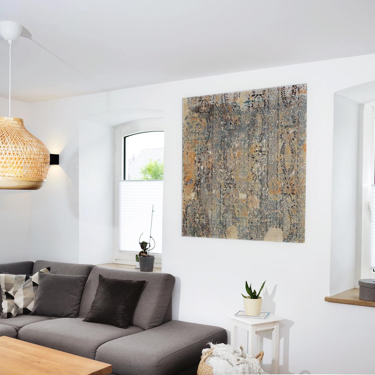 Wohnzimmerecke mit Sofa, Rattanleuchte und großem Wandbild