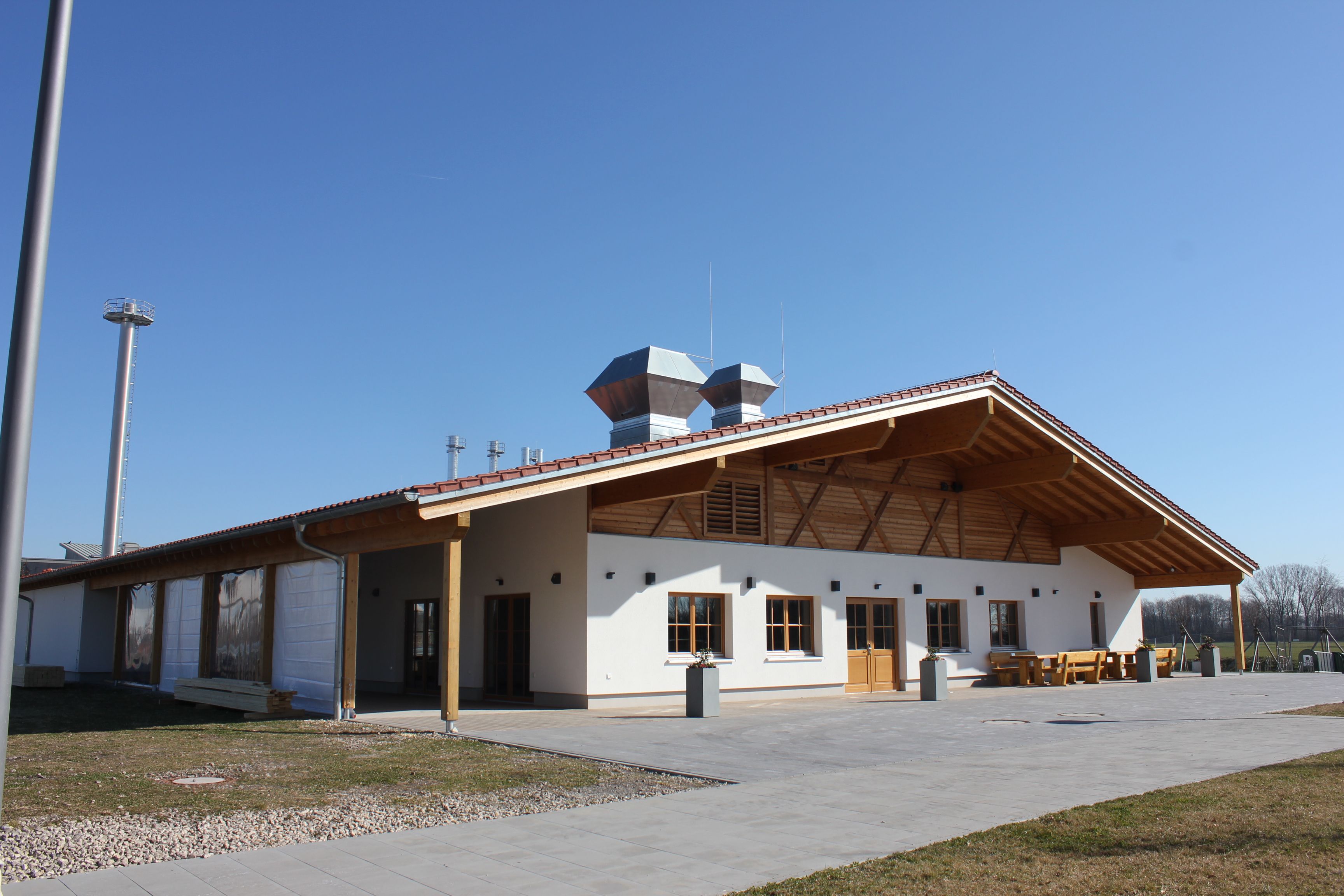Feststadl Unterföhring — Veranstaltungshalle mit Holzvertäfelung, Theke, Bestuhlung, Holzbalkendecke