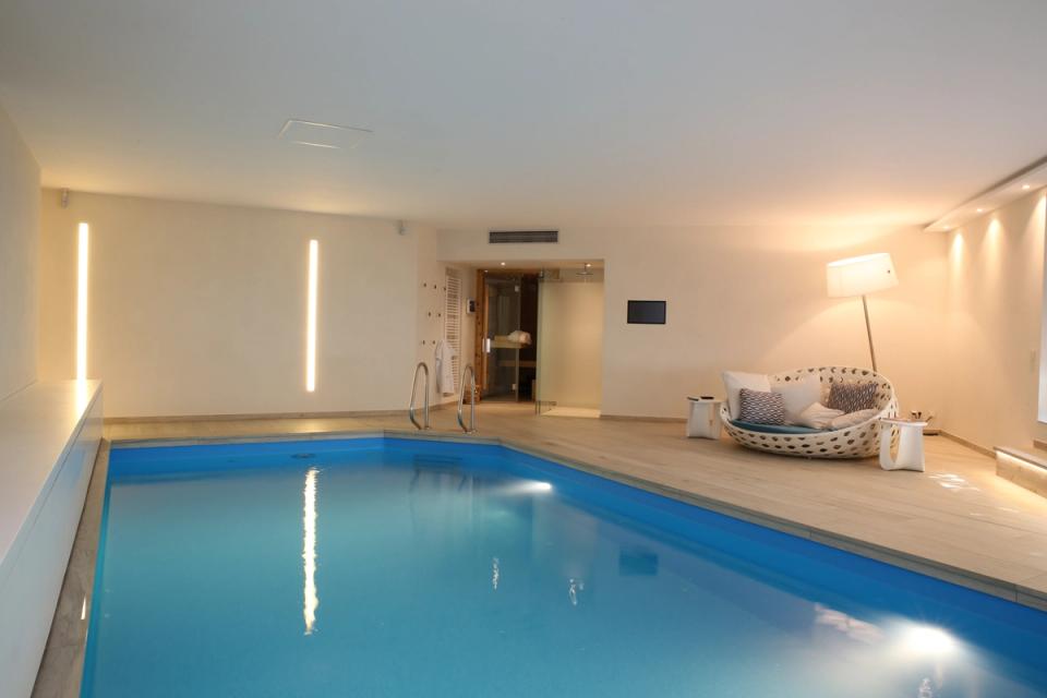 Indoor-Pool/Hallenbad mit Sauna im Hintergrund, Lounge-Bereich