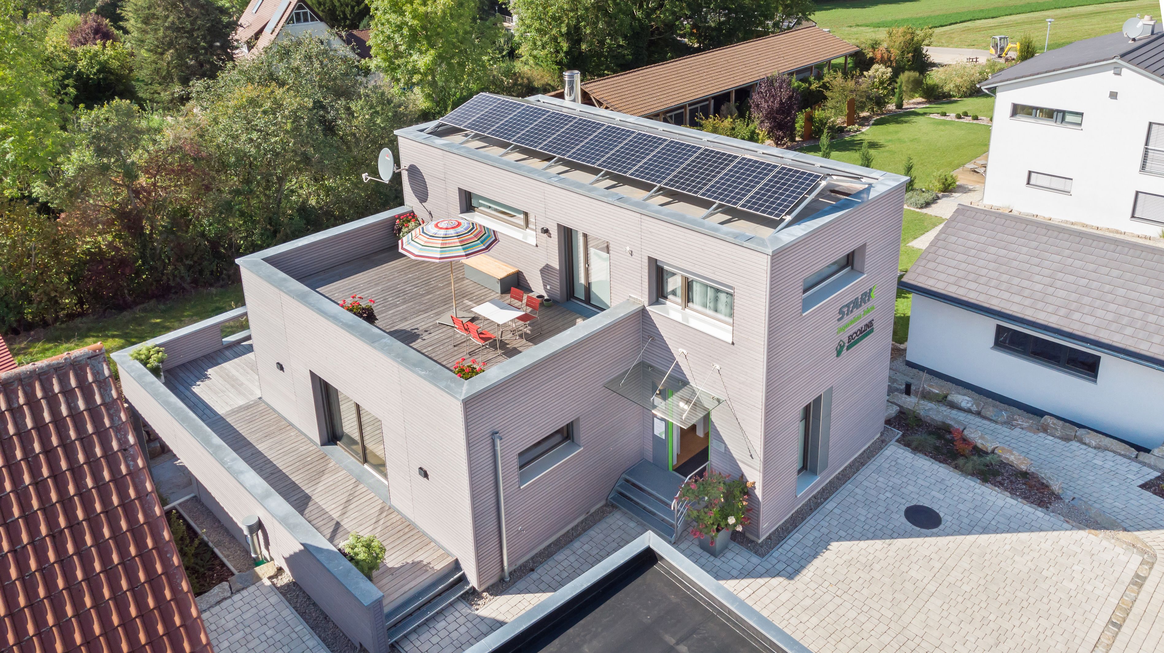 Luftaufnahme des Musterhauses 2inEins mit Dachterrasse und Photovoltaik