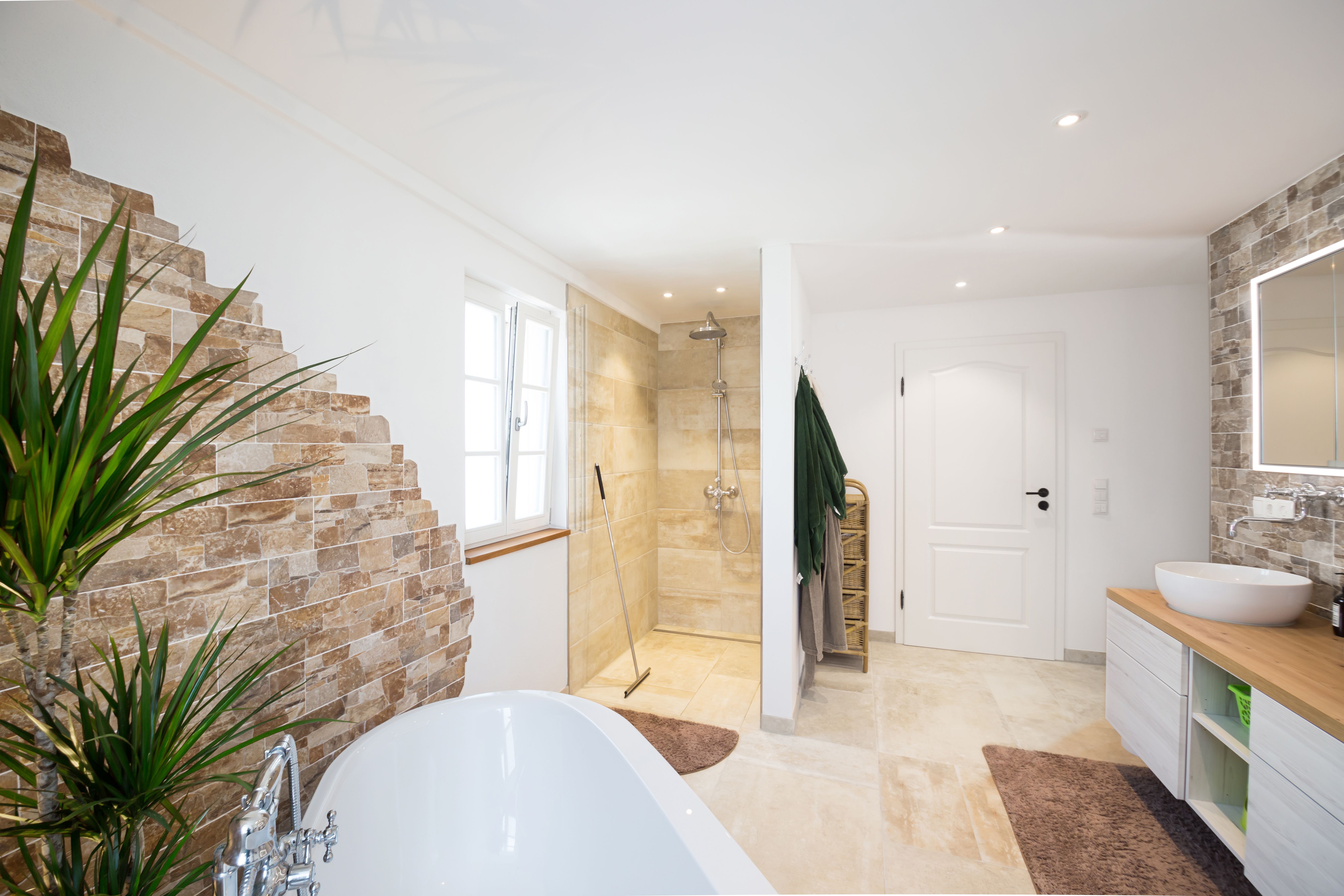 Bad mit Natursteinwand und freistehender Wanne