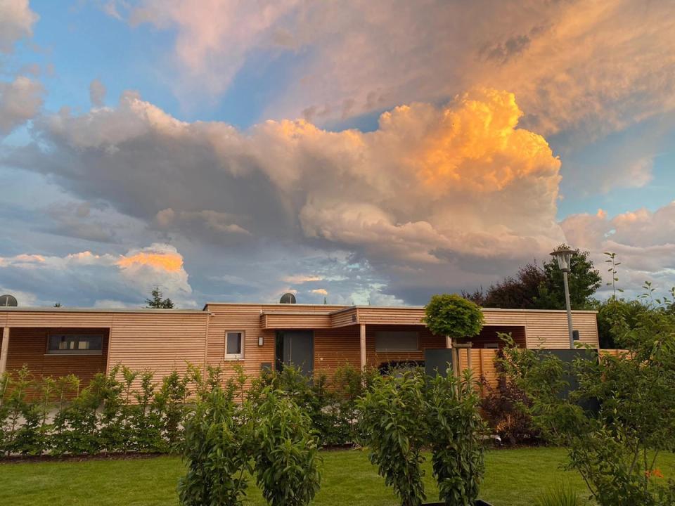 Abendhimmel mit leuchtenden Wolken über dem flachen Atriumhaus