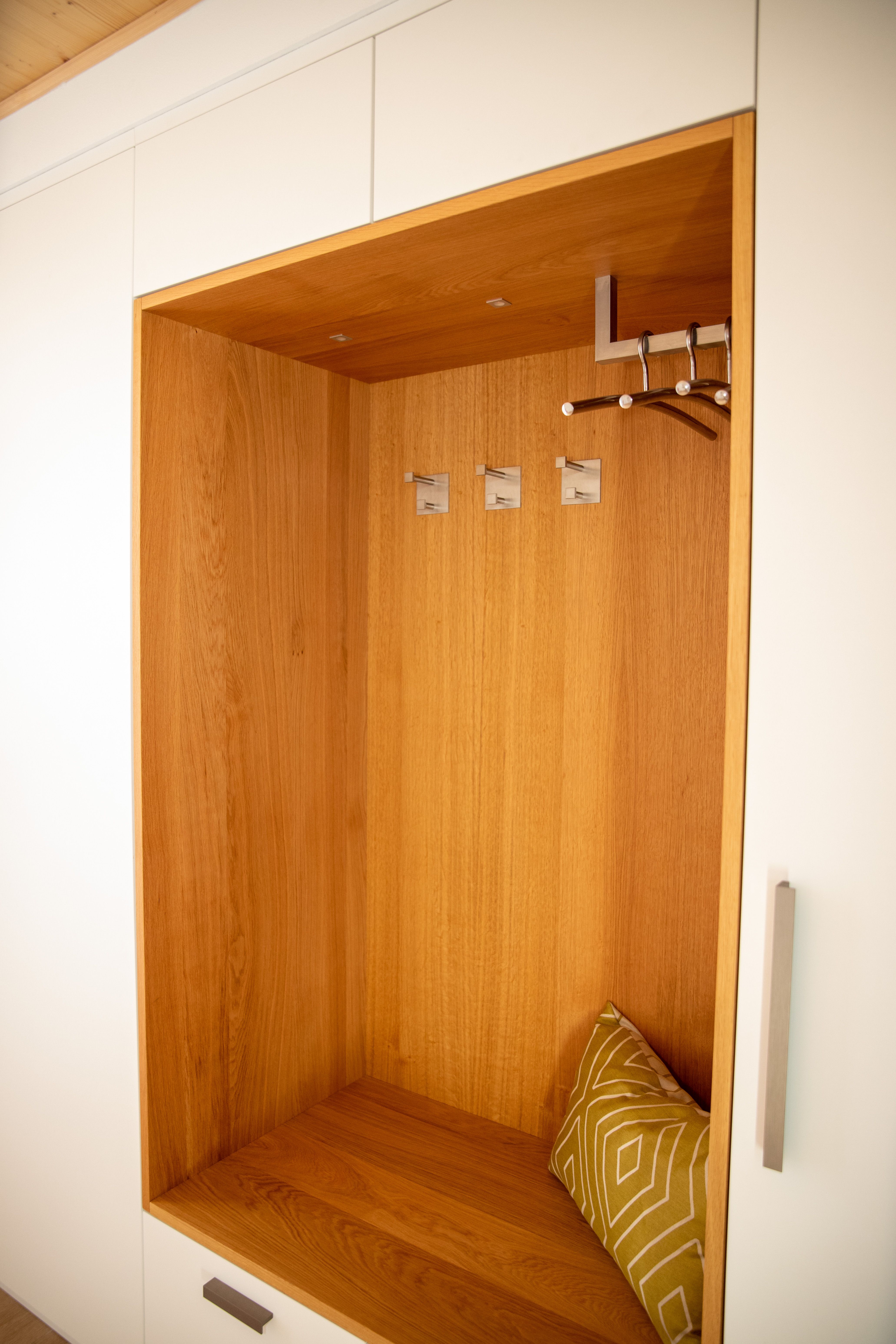 Beleuchtete Eichennische der Garderobe mit Haken und Sitzkissen