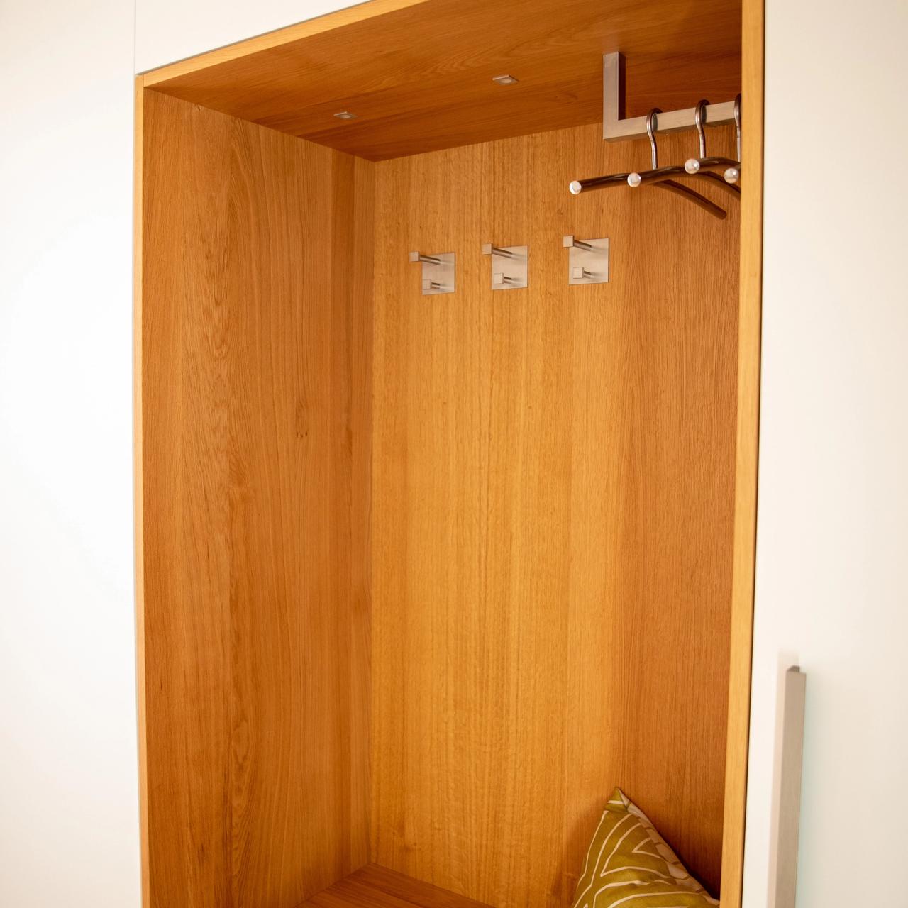 Beleuchtete Eichennische der Garderobe mit Haken und Sitzkissen