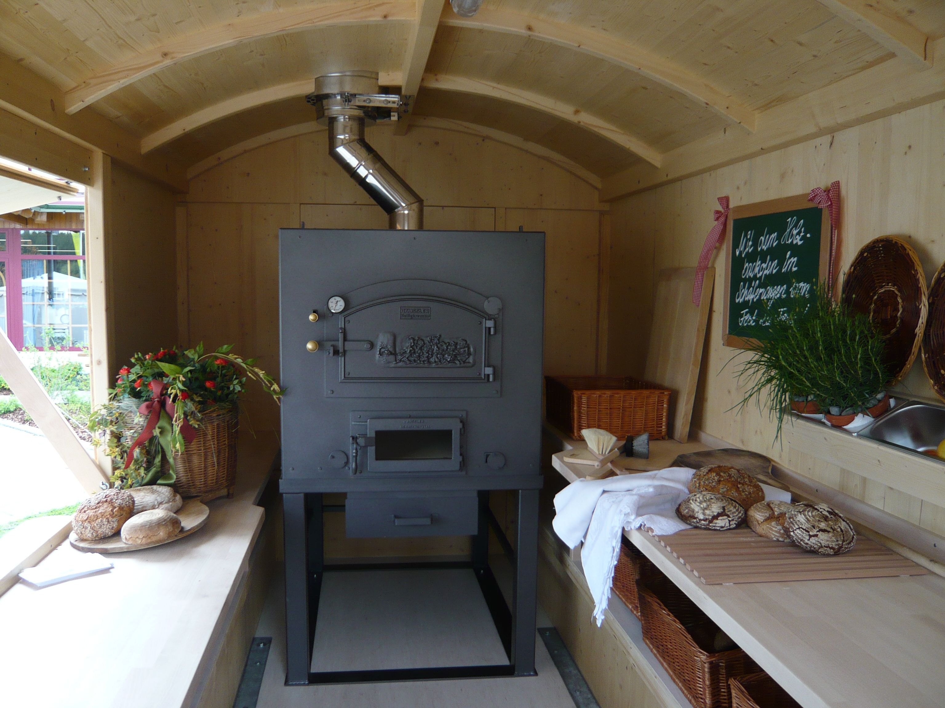 Holzbackofen mit frischem Brot im Backwagen