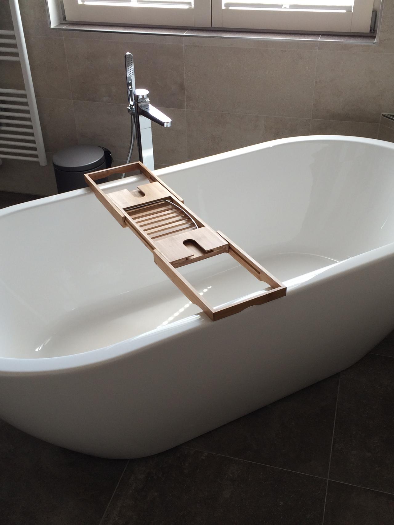 Freistehende Badewanne mit Holzablage am Fenster