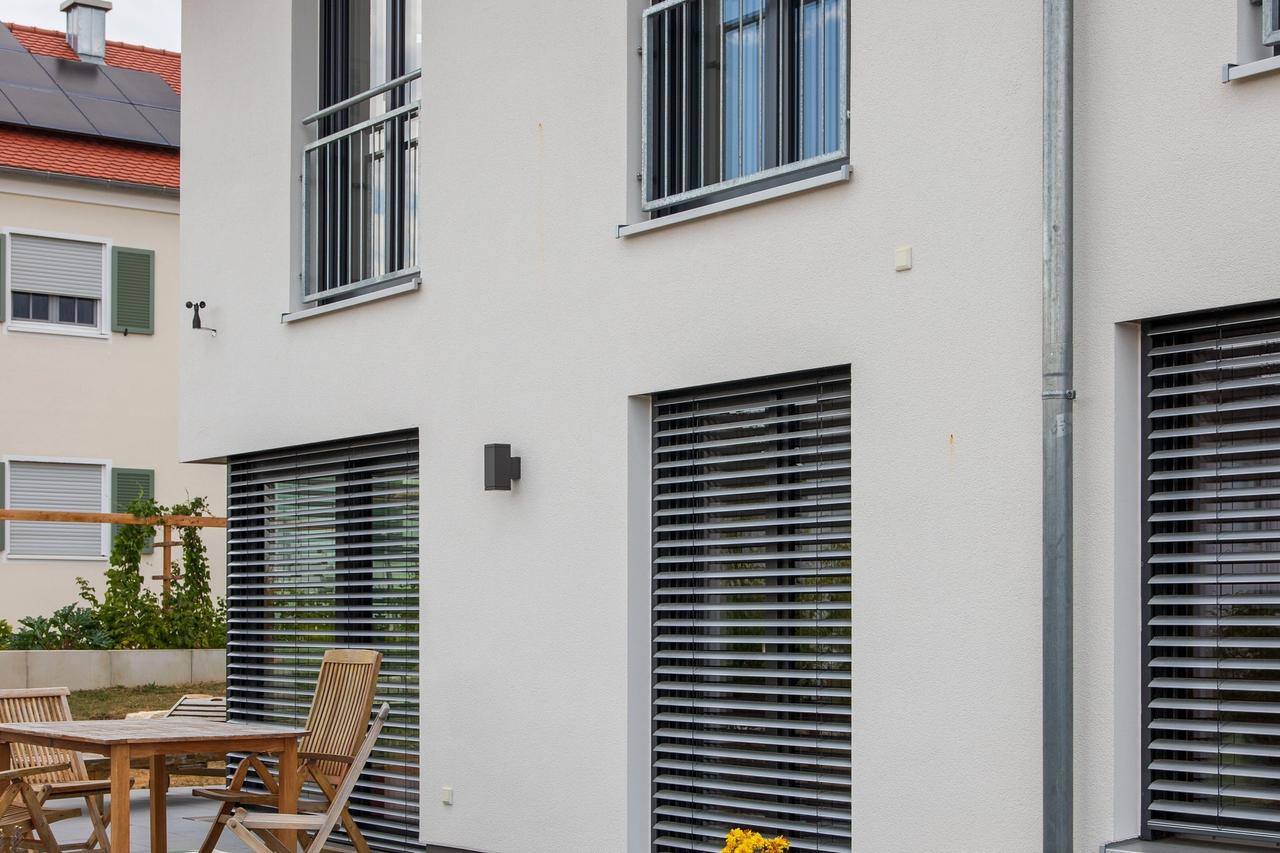 Terrasse mit Raffstores, Gartenmöbeln und Trockenmauer