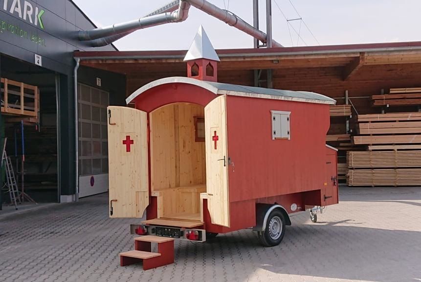 Roter Kirchenwagen mit Türmchen und geöffneten Flügeltüren