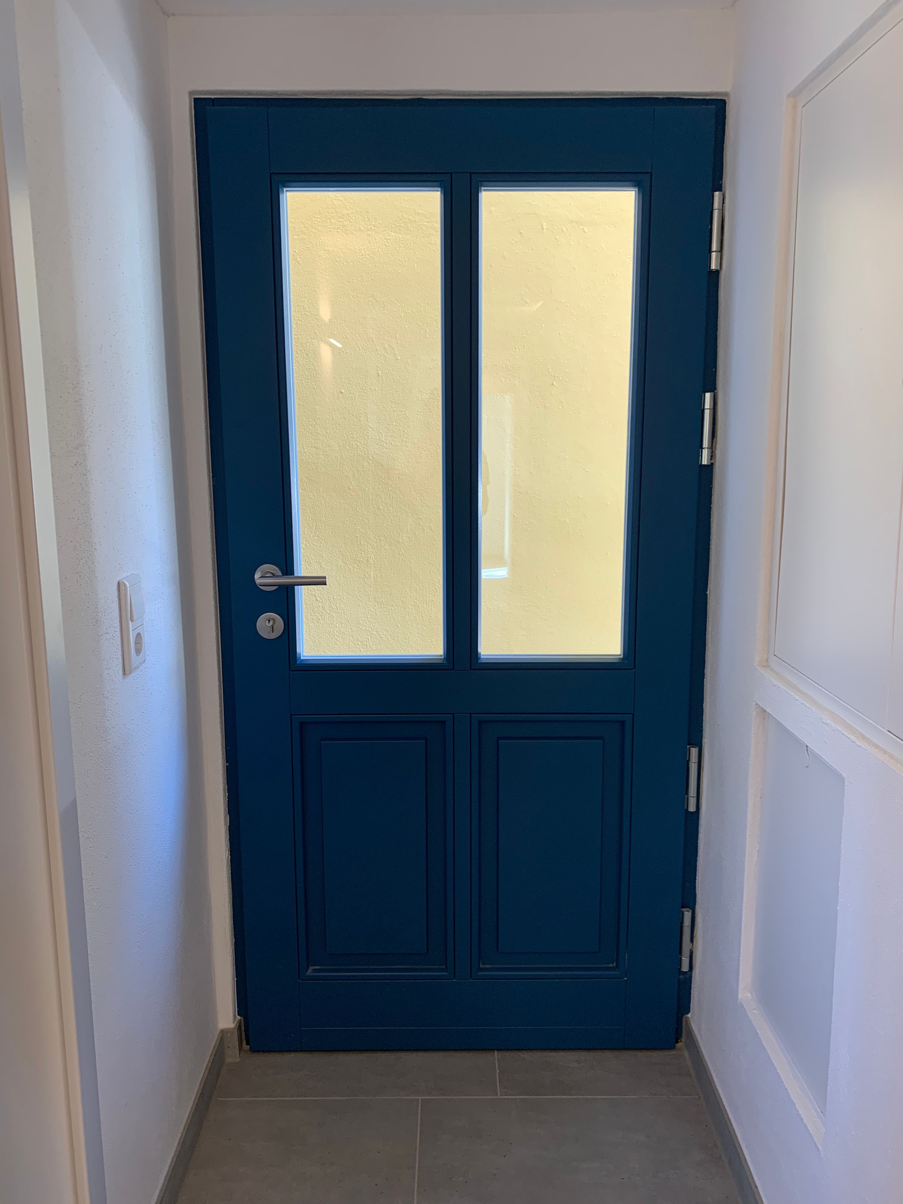 Blaue Wohnungstür mit Glasfeldern