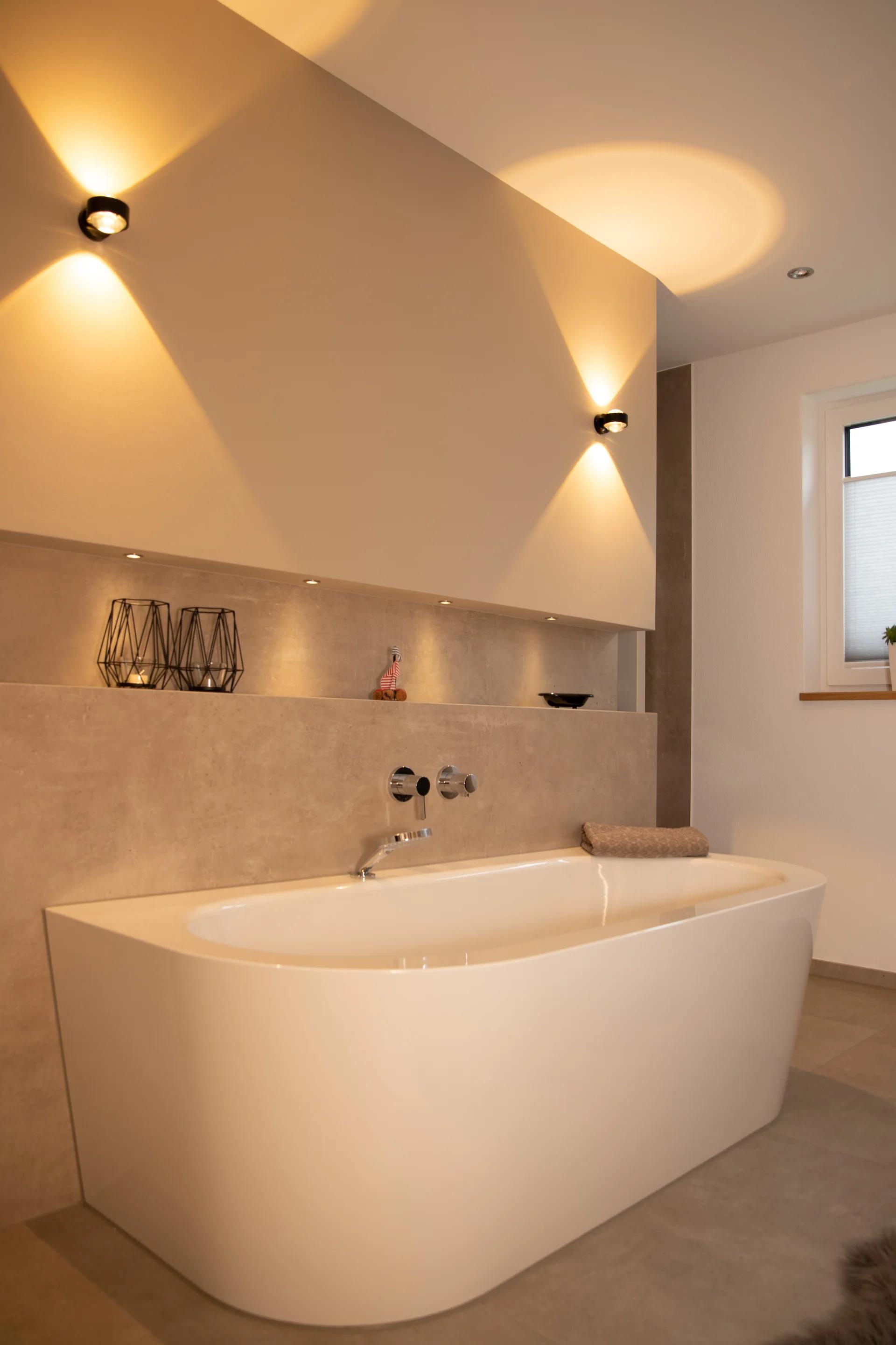 Freistehende Badewanne mit Betonoptik-Nische, atmosphärisch — Zimmerei Stark