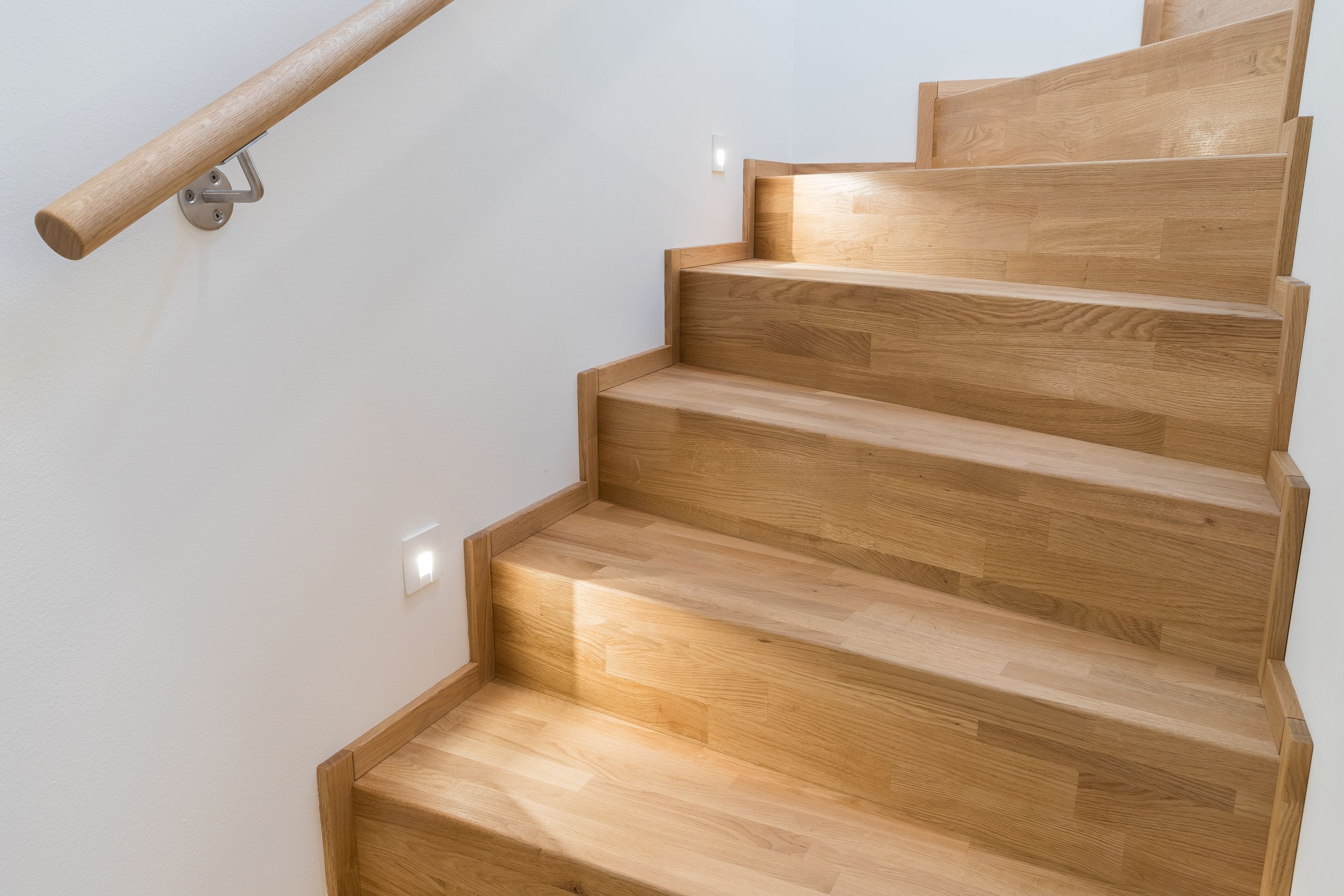 Holztreppe aus Eiche mit Handlauf und eingelassener Stufenbeleuchtung
