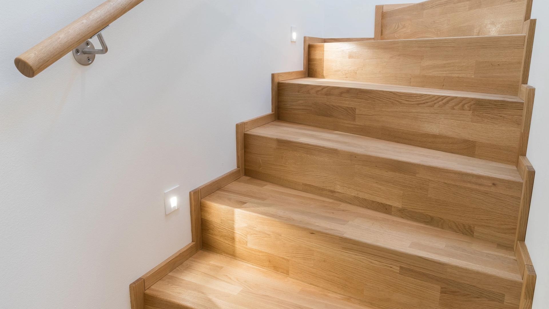 Holztreppe aus Eiche mit Handlauf und eingelassener Stufenbeleuchtung