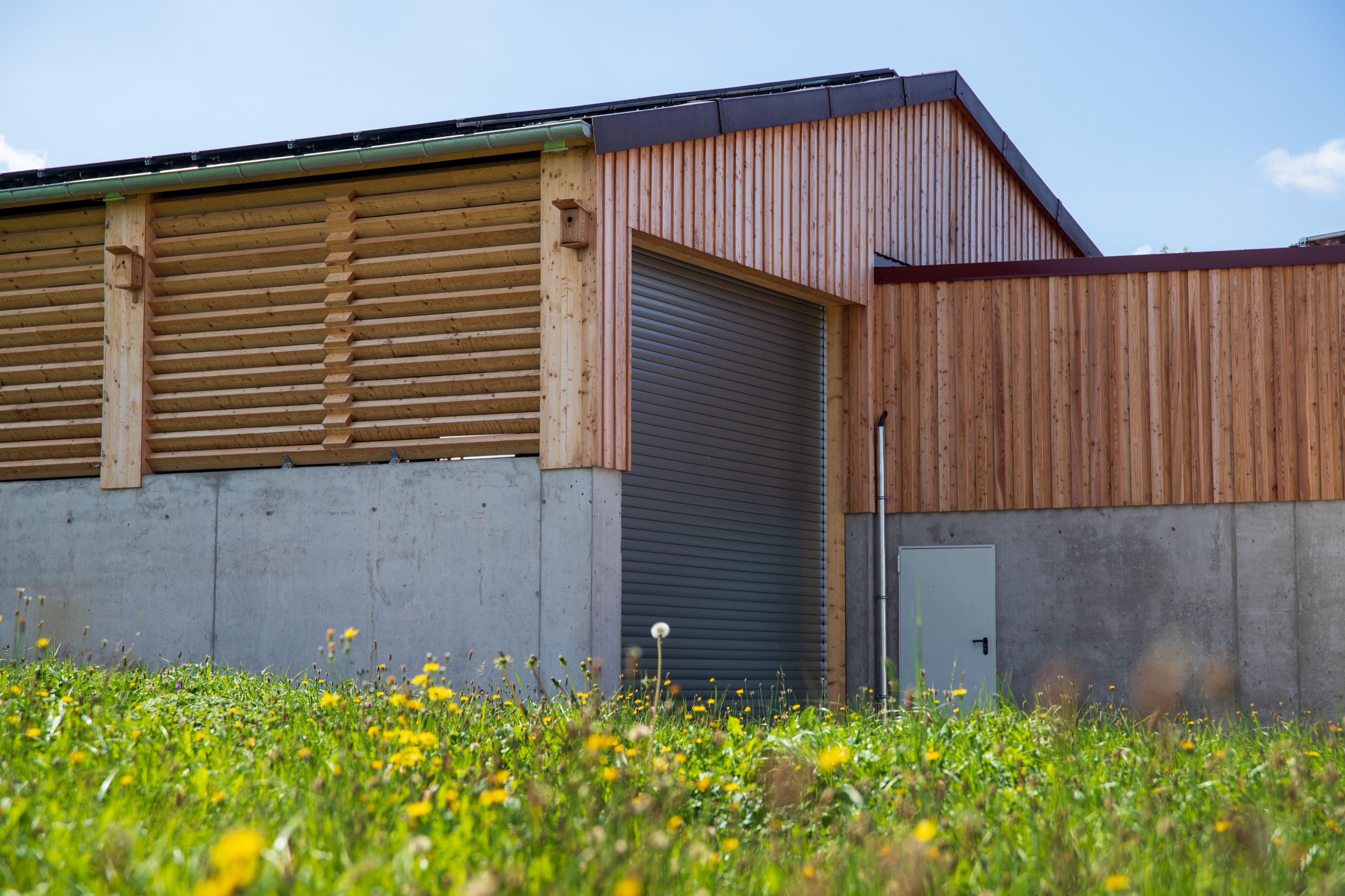 Wärmenetz Stopfenheim Lagerhalle — Außenansicht Ostseite, Holz-/Betonfassade