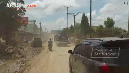Jalan Lintas Sumatera di Aceh Tamiang dipenuhi debu tebal akibat lumpur sisa banjir yang mengering dan terbawa angin saat kendaraan melintas.