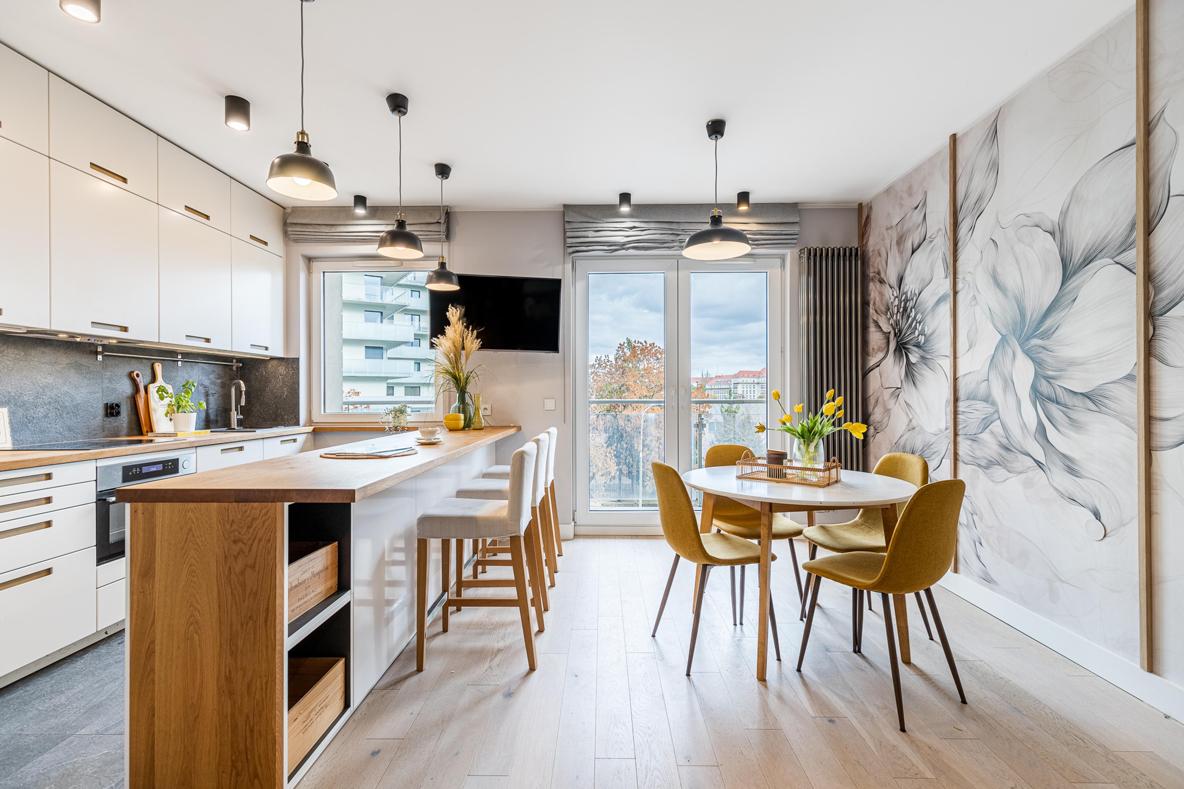 Cozinha moderna e sala de jantar em apartamento à venda em Wrocław – interior espaçoso com ilha na cozinha, elementos de madeira e vista panorâmica. Imóvel ideal para investimento em 2025.