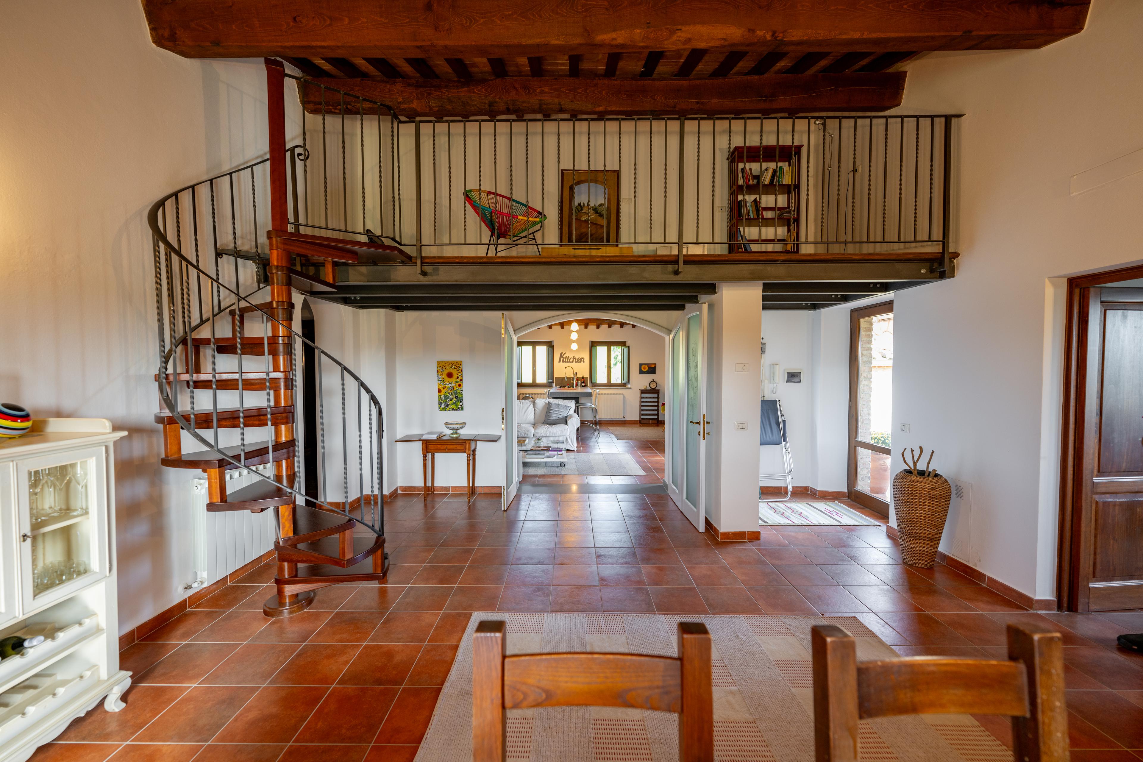 Interno elegante di un appartamento in vendita in Umbria con soppalco e travi in legno – proprietà italiana ideale per gli amanti dello stile rustico