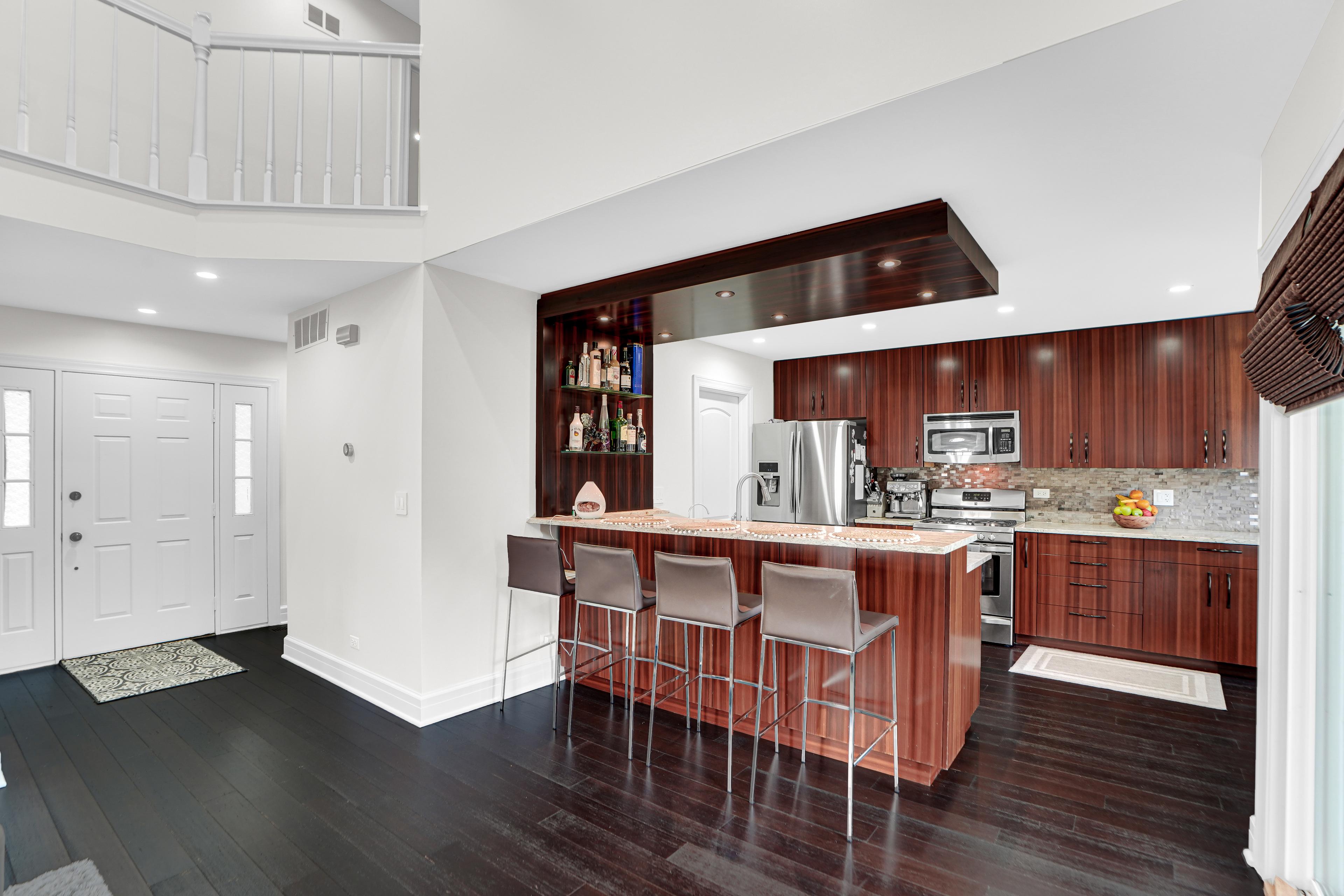 Cocina moderna en un apartamento en venta en Chicago: elegante carpintería de madera, electrodomésticos de alta gama y una isla de cocina con asientos. Interior espacioso ideal para familias e inversores. ¡Consulta la oferta de inmuebles en Chicago!