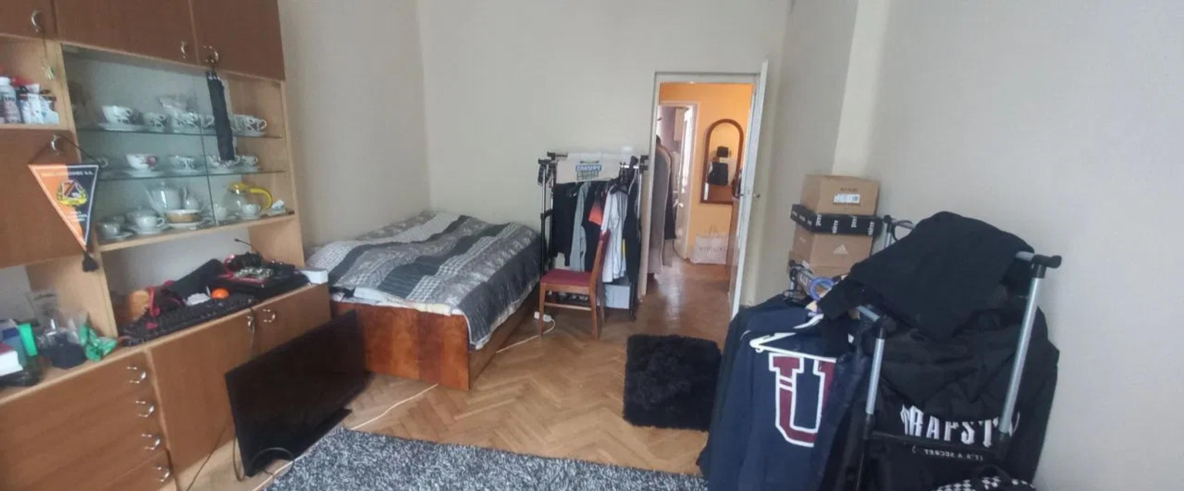 Rom i en eiendom til salgs som trenger home staging og optimalisering for salgstrategi. Området er rotete, noe som kan gi et negativt førsteinntrykk hos kjøpere. Nøkkeltrinn for forbedring inkluderer å depersonalisere interiøret, rydde i rommet, og bruke profesjonell eiendomsfotografering for å øke attraktiviteten og markedsverdien.