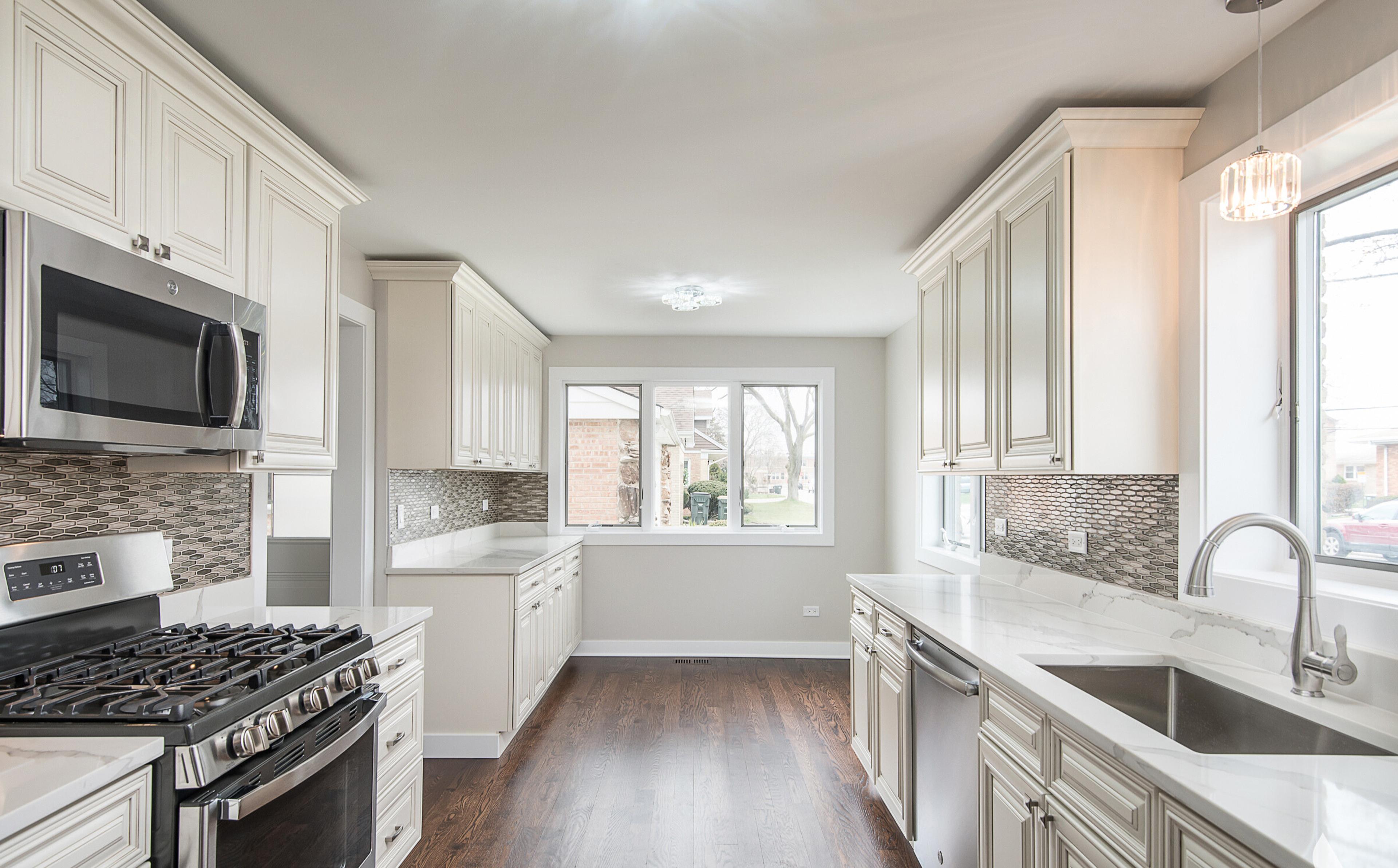 Cocina moderna en una casa en venta en Chicago: carpintería elegante de estilo clásico, encimeras de mármol, suelo de madera y electrodomésticos de alta calidad. Interior espacioso y luminoso, ideal para familias e inversores. ¡Consulta las ofertas de inmuebles en Chicago!