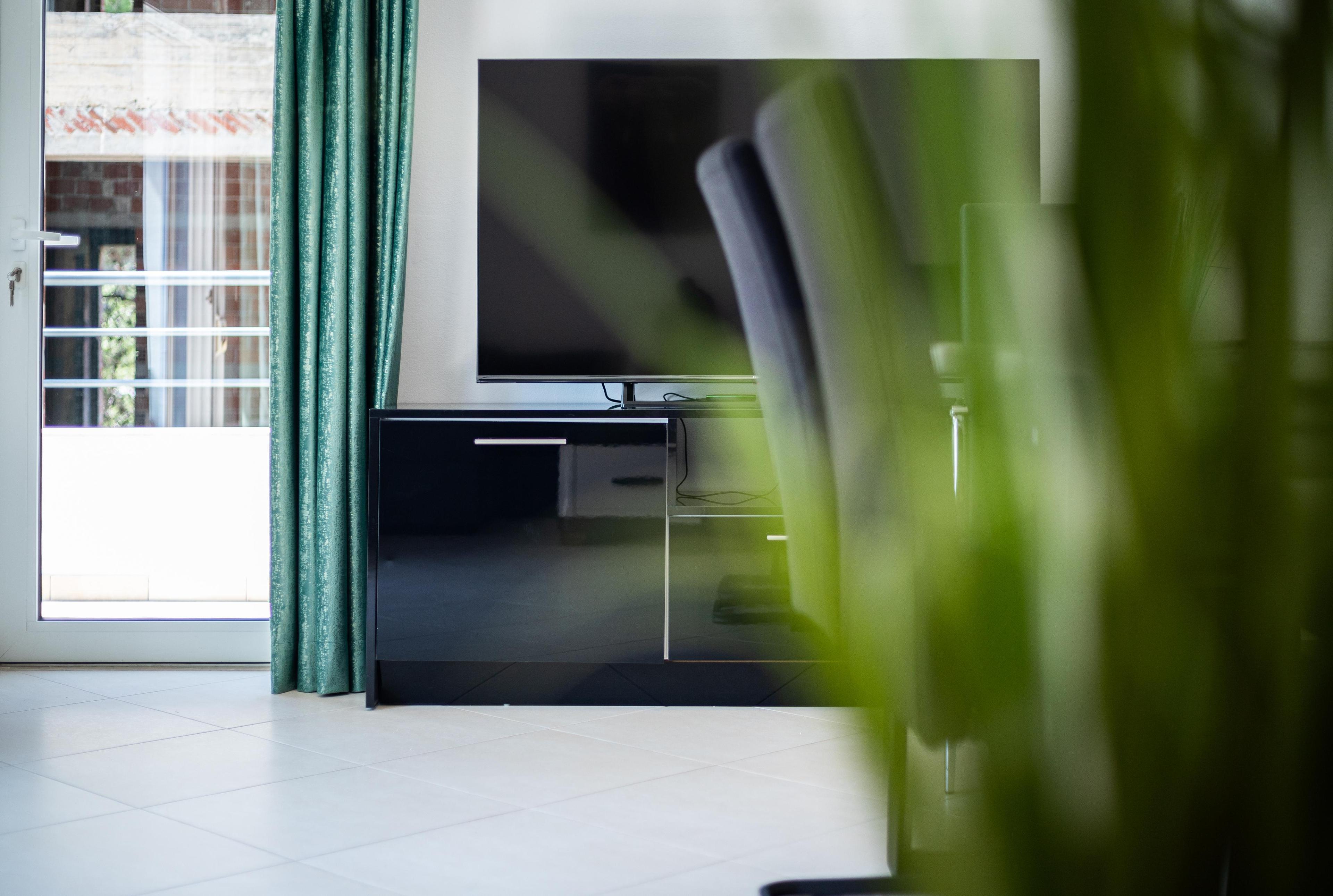 Przytulny salon z telewizorem w nowoczesnym apartamencie Golem Albania – idealne nieruchomości nad morzem do inwestycji i zakupu w 2025