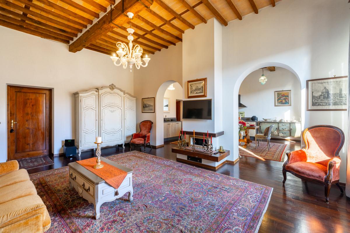 Apartament elegant de închiriat în Toscana – living spațios în stil clasic, cu grinzi de lemn și decor rustic. Proprietate de lux de vânzare în Sansepolcro.