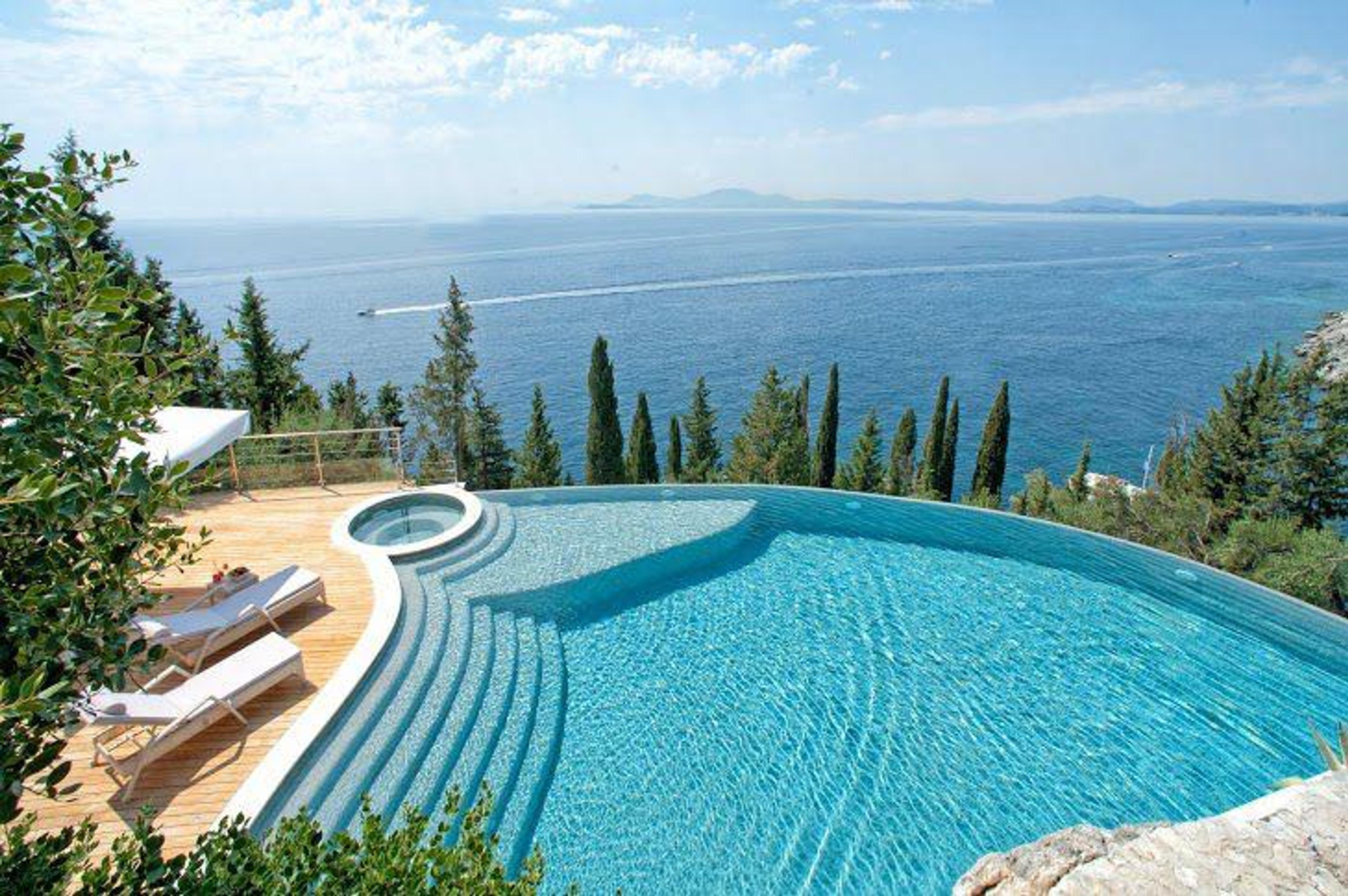Lyxig infinity-pool med havsutsikt – fastigheter Grekland vid havet priser i premiumsegmentet, perfekta villor med pool Grekland för investering i semesterhus Grekland till salu och programmet golden visa Grekland fastigheter på grekiska öar.