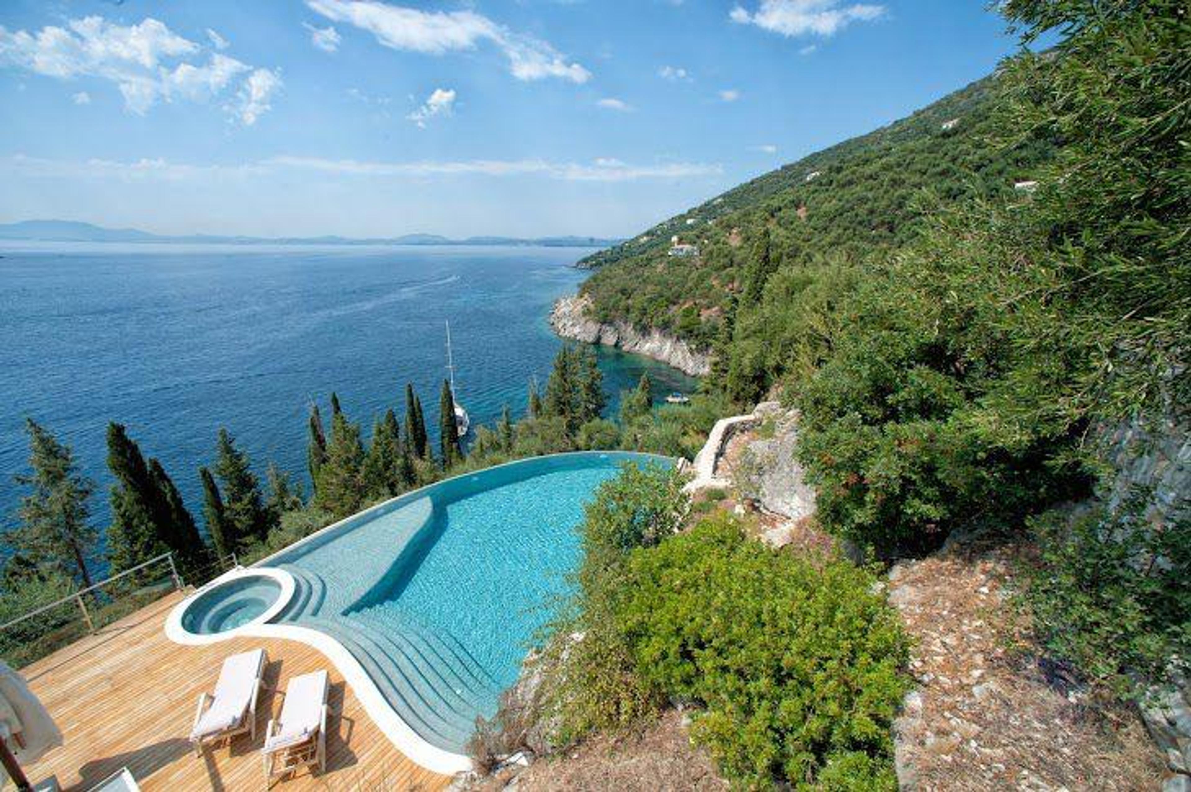Infinity-pool på klippa ovanför Egeiska havet – spektakulär villa med pool Grekland på de grekiska öarna, visar varför det är värt att köpa lägenhet i Grekland som investering i fastigheter Grekland vid havet priser premium för golden visa Grekland fastigheter.