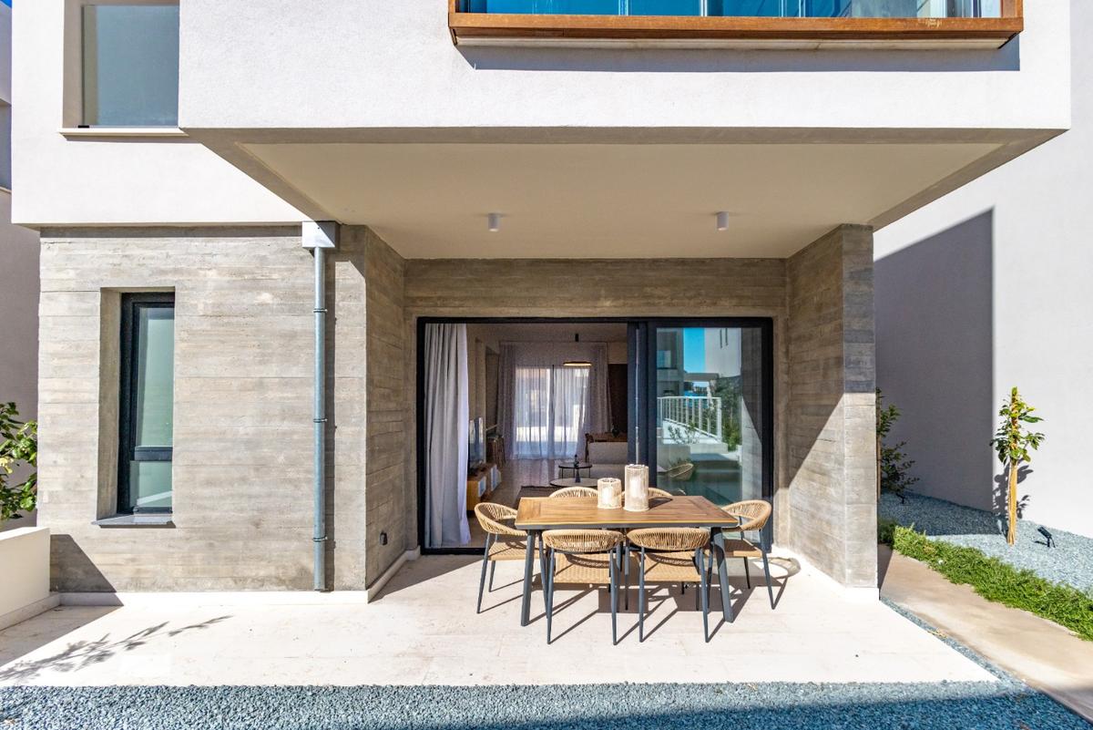 Μοντέρνα βεράντα ακινήτου στην Κύπρο με εξωτερική τραπεζαρία και γυάλινη είσοδο στο διαμέρισμα