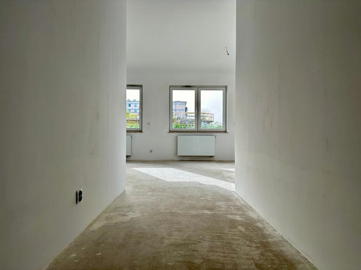 Moderni asunto rakennusvaiheessa - valoisa käytävä, joka johtaa tilavaan olohuoneeseen, jossa on kolme ikkunaa ja patteri. Luonnonvalo, joka tuo esiin minimalistisen designin. Täydellinen tila sisustettavaksi.