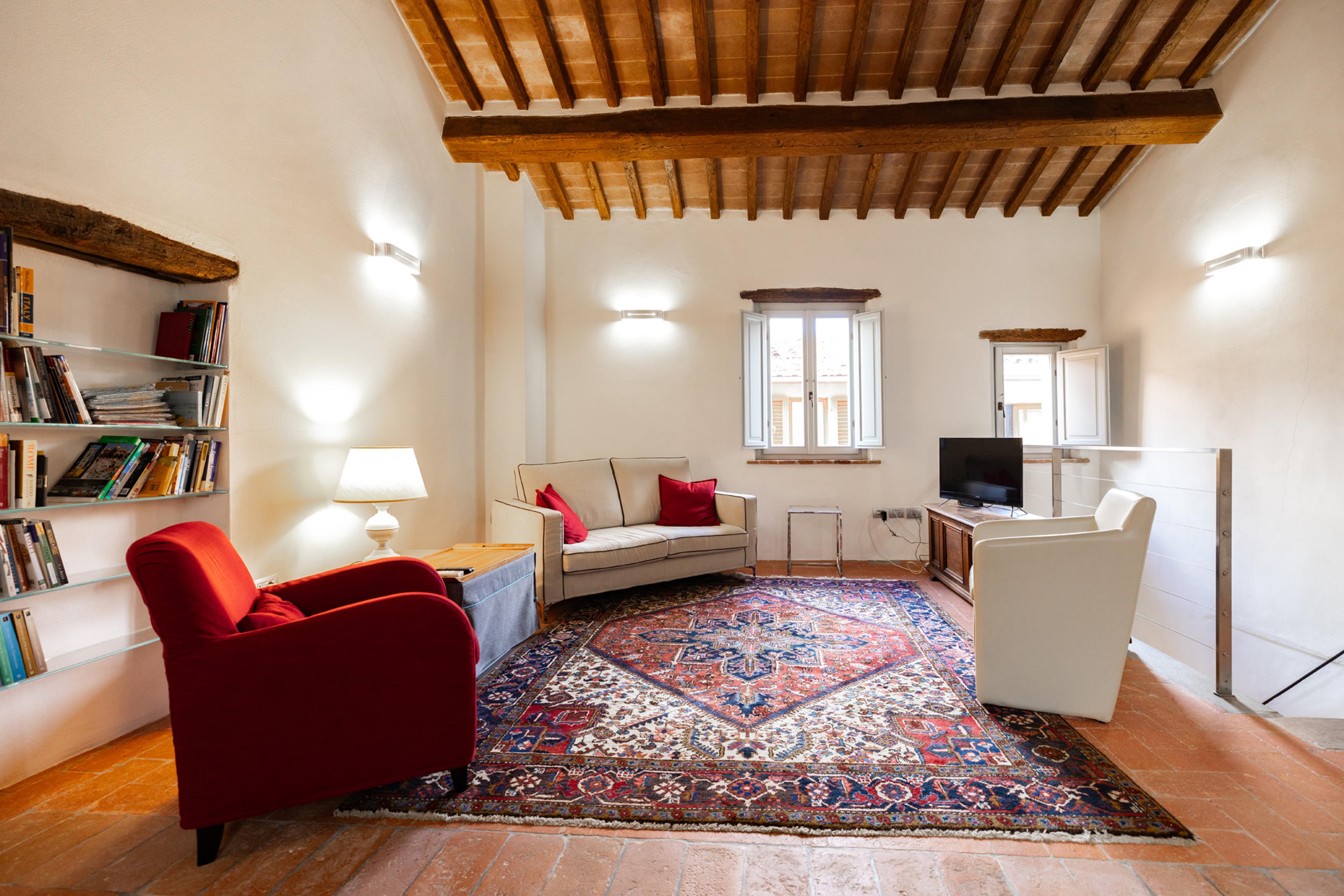 Cozy living room in an apartment in Tuscany – elegant interior with wooden beams, rustic finish, and classic decor. Property for sale in Sansepolcro.