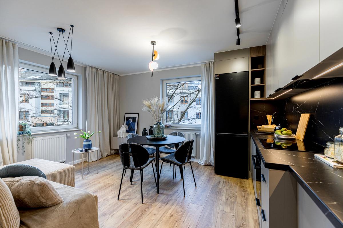 Moderní obývací pokoj v apartmánu na prodej ve Wrocławi – prostorný interiér, přirozené světlo a elegantní dokončení. Ideální nemovitost pro investory i rodiny.