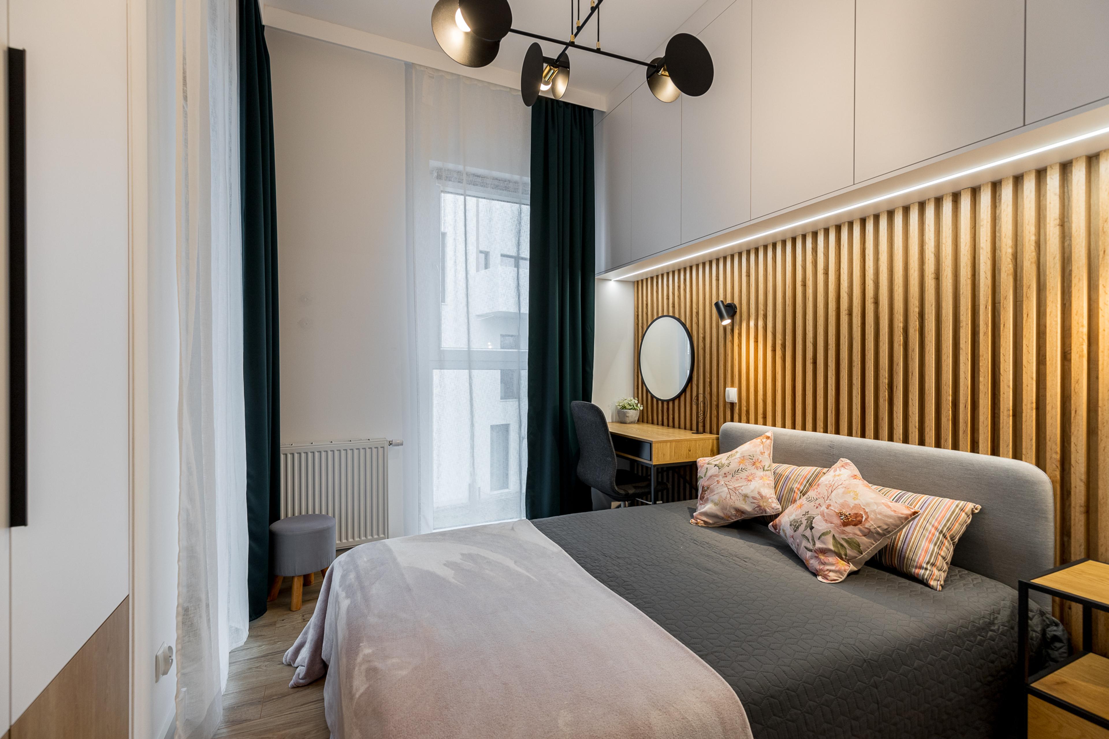 Quarto aconchegante em novo apartamento em Wrocław – painéis de madeira, iluminação de design e cama confortável. Apartamento ideal para investidores e pessoas que procuram imóveis para aluguel.