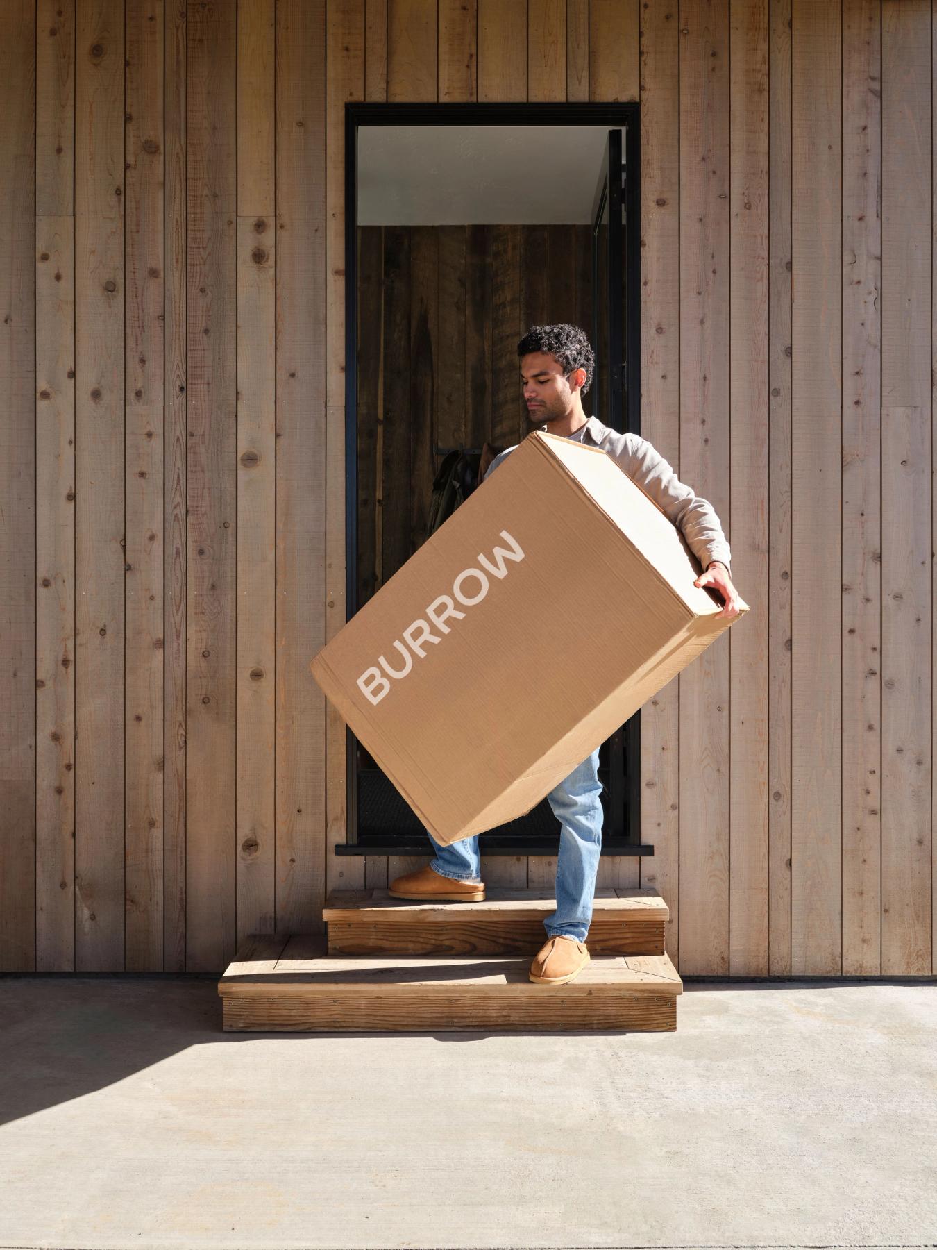 Customer receiving Burrow furniture in boxes delivered to his front door