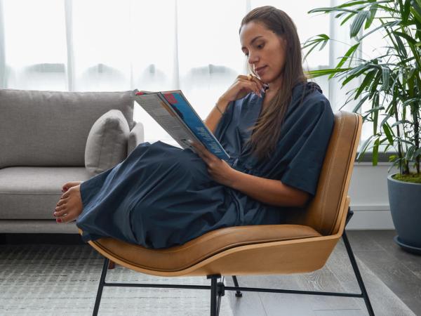 Woman curled up reading in brown leather chair