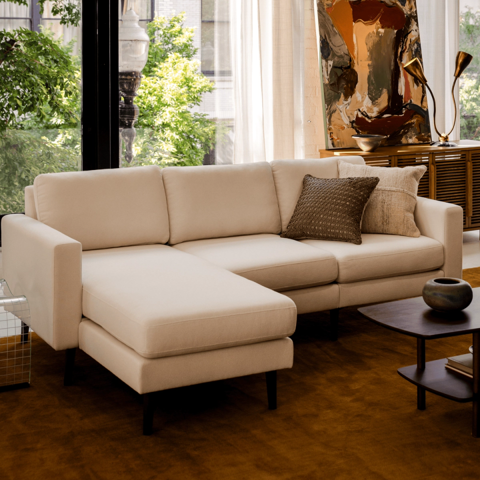 Cream chaise sectional with throw pillows in a sunlit living room