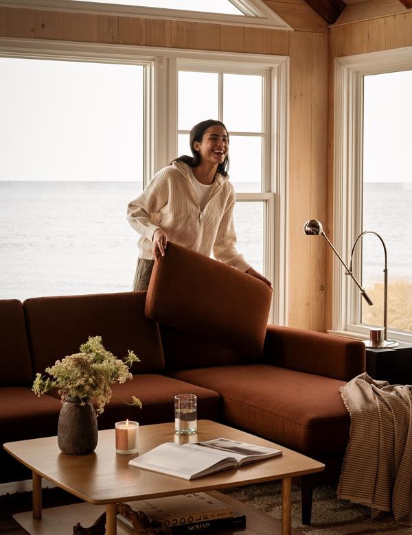 Nomad sectional in sienna by a window overlooking the water